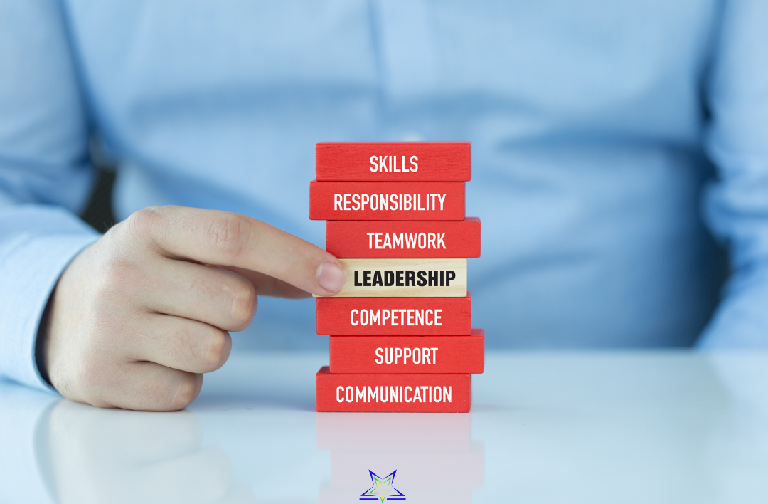 Stack of red and beige blocks with words: communication, support, competence, leadership, teamwork, responsibility, skills, with a person pointing to the leadership block.