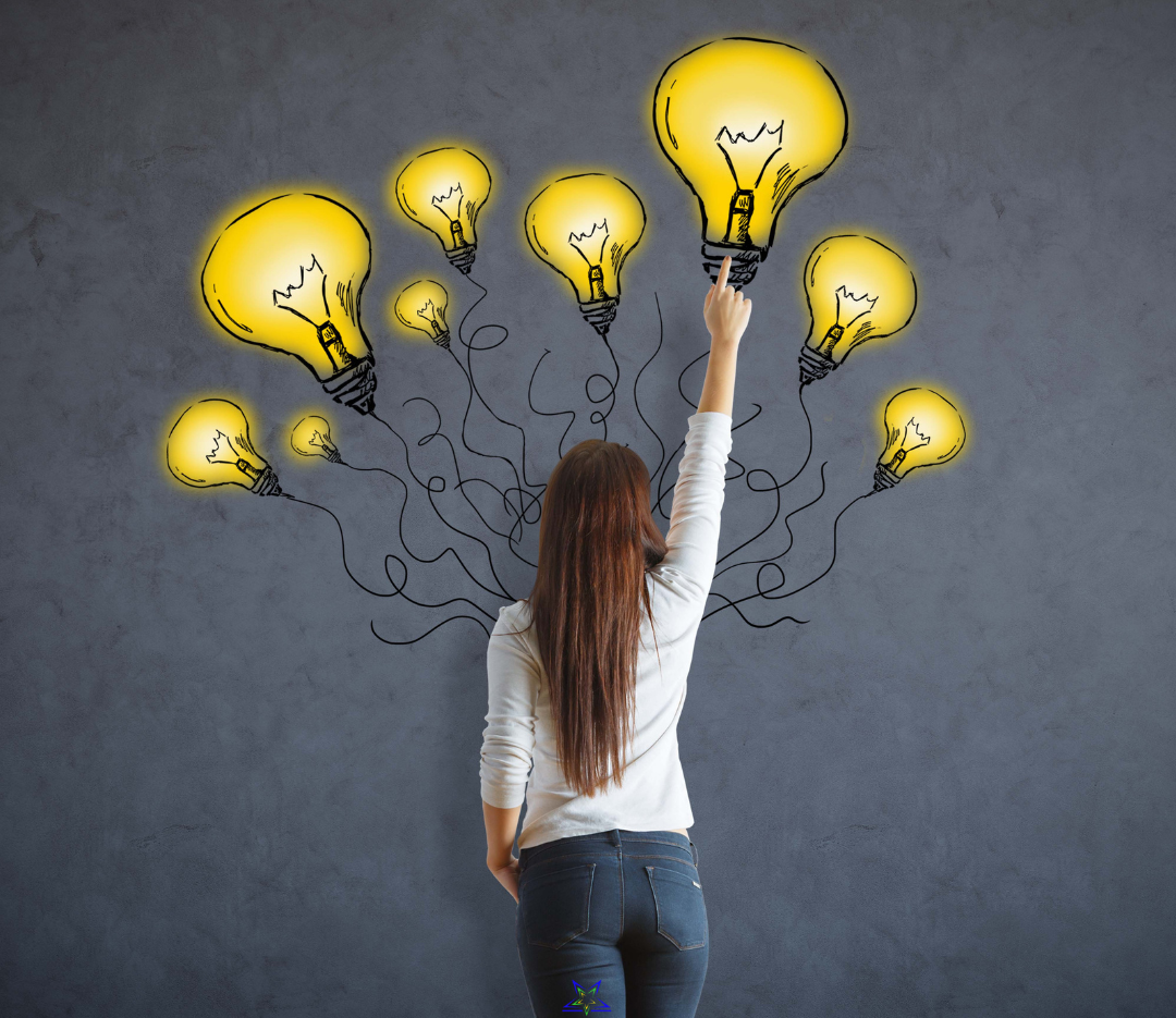 Image shows a woman with long, brown hair wearing a white top and blue jeans. She is facing away from us and reaching up to point at an illuminated lightbulb graphic, one of 9, on the wall above her