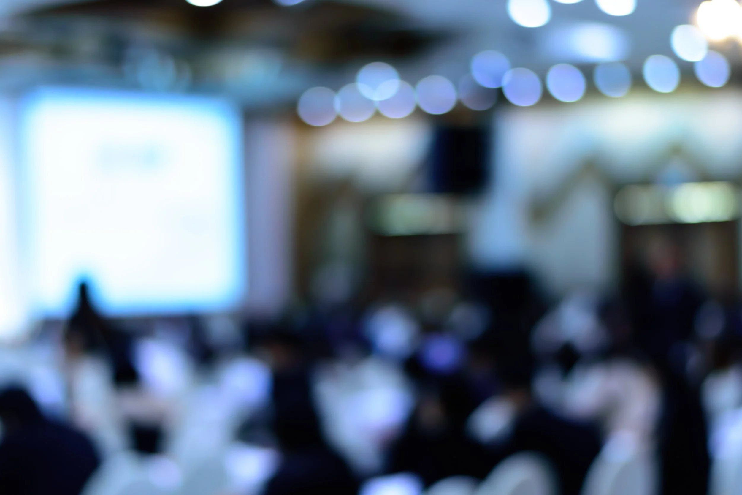 Blurred image of colorful lights with bokeh effect, possibly in an indoor setting.