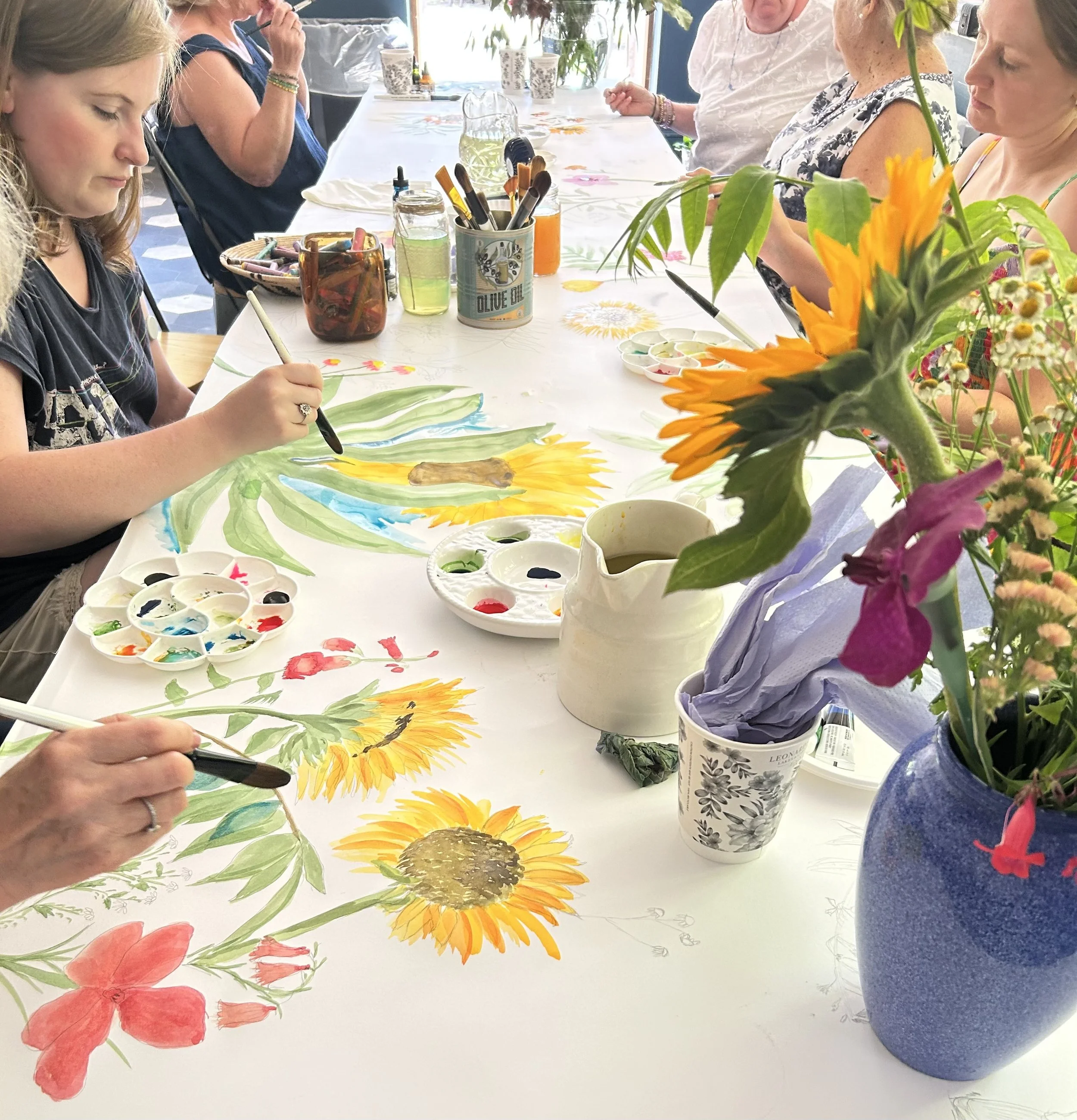 Participants in workshop using acrylic paints to add colour to their pencil drawings of botanicals.