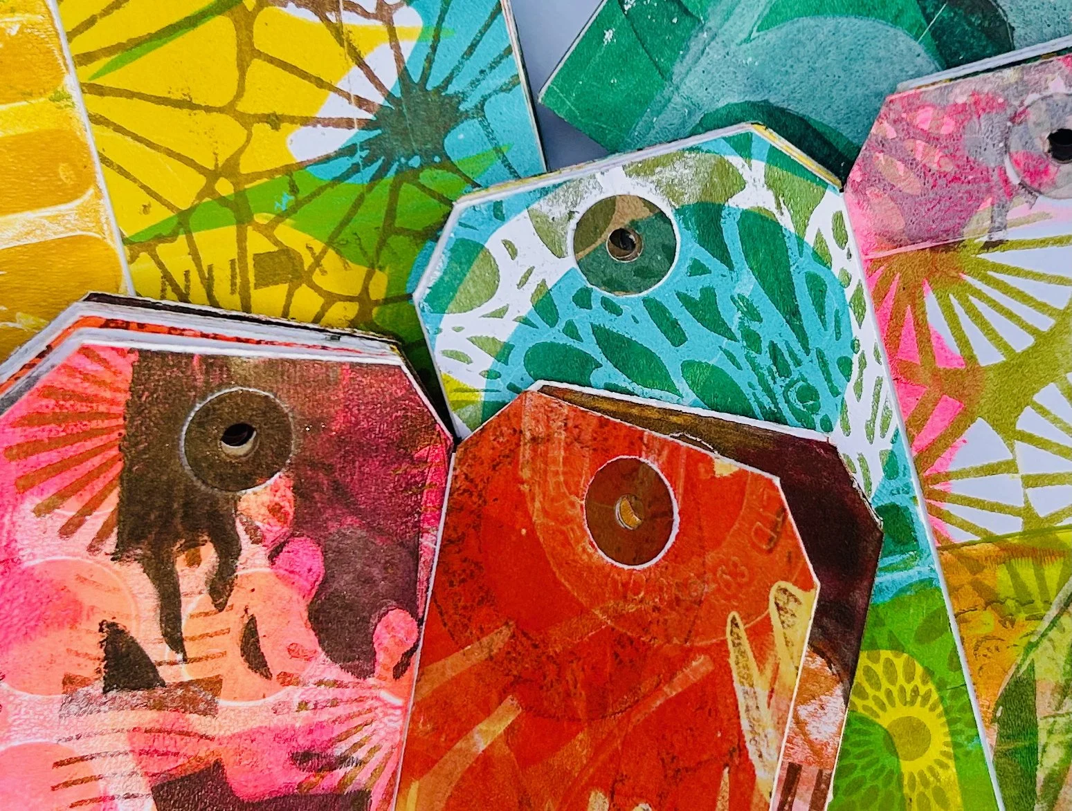 Gelli printed tags and mini tag books created using botanicals and stencils during a One More Print workshop.