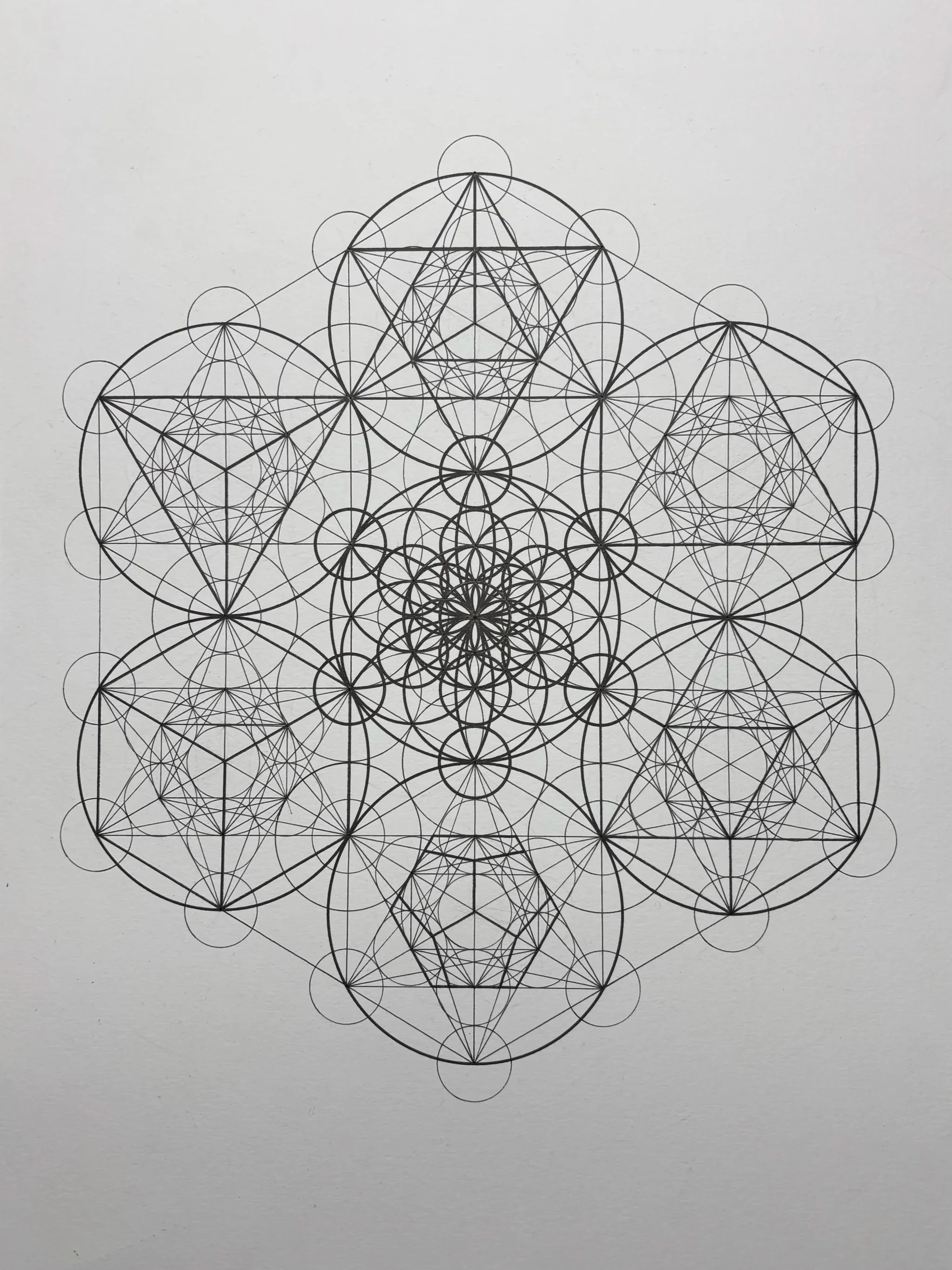 Geometrisk mønster bestående af mange sammenfiltrede cirkler og linjer i sort på hvid baggrund.