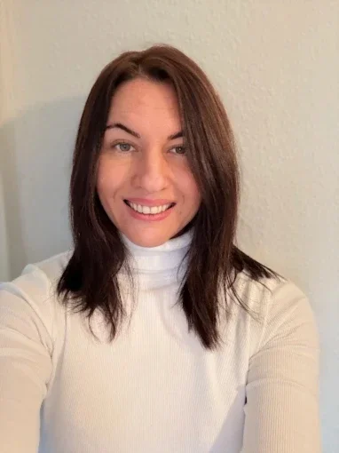 Eileen Schneider blickt lächelnd und mit wachem, energiegeladenem Ausdruck direkt in die Kamera. Ihr vitales Erscheinungsbild unterstreicht ihre positiven Rezension über Heilpraktikerin Beatrice Bayer.