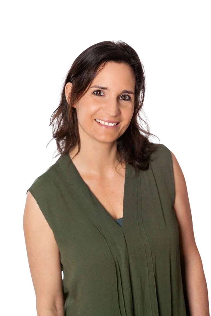 Heilpraktikerin Beatrice Bayer blickt lächelnd und souverän in einer Frontalansicht direkt zum Betrachter. Sie trägt eine helle Strickjacke über einem dunkelgrünen Oberteil und strahlt eine ruhige, einladende Professionalität aus, die ideal geeignet