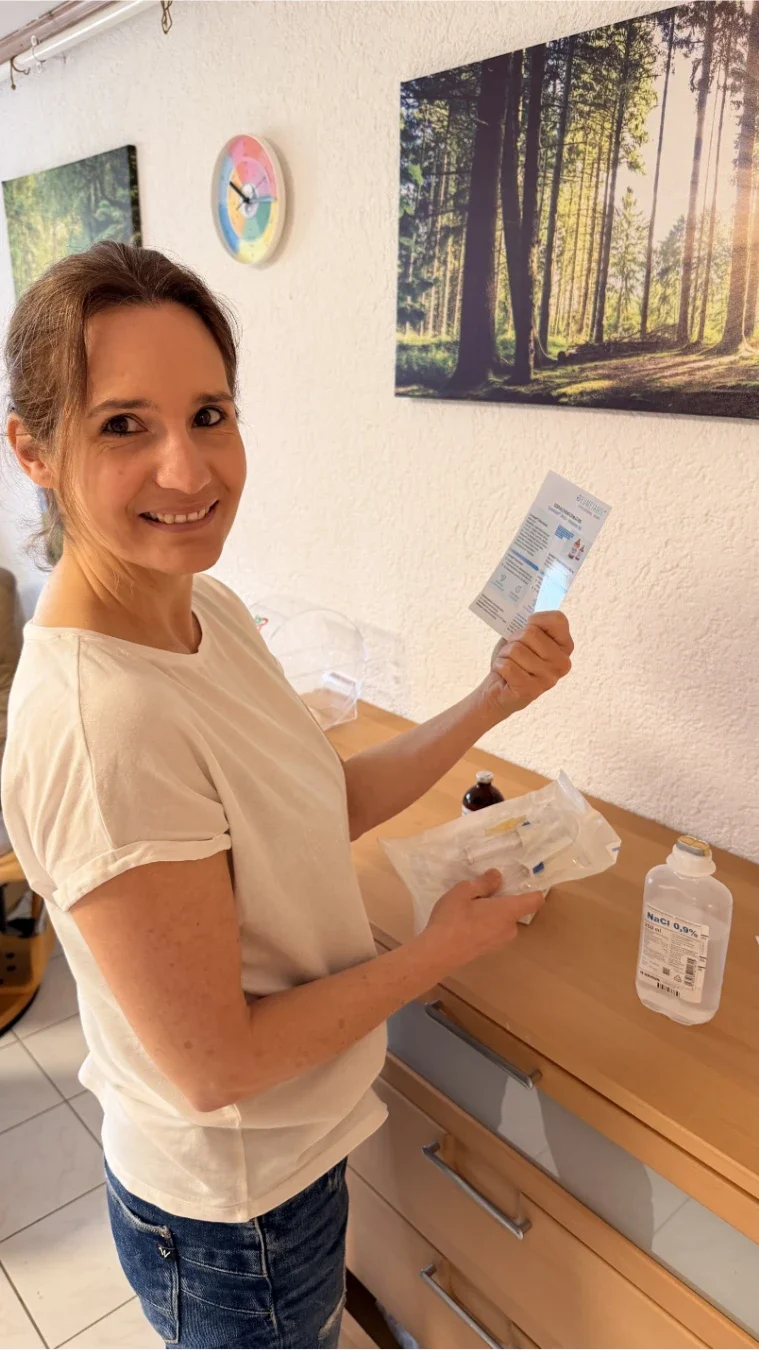 Heilpraktikerin Beatrice Bayer bereitet in ihrer hellen Praxis Infusionszubehör und Labordaten vor. Das Bild unterstreicht ihre Philosophie „Klarheit durch Daten“ und zeigt den Fokus auf moderne Labordiagnostik zur gezielten Ursachenforschung.