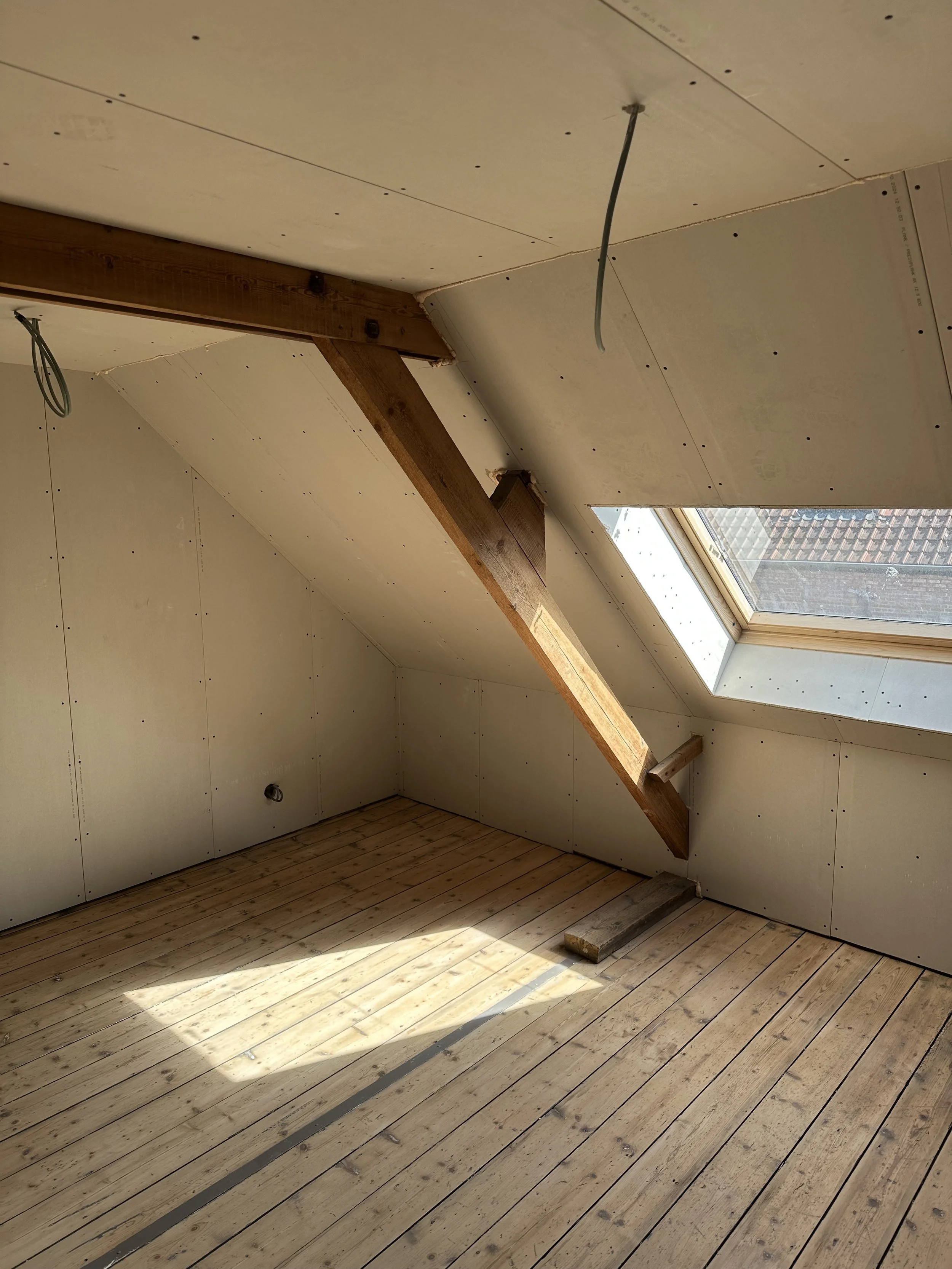 Gyprocwerken op zolder met dakraam, afwerking op maat door Sorgeloose in Brugge