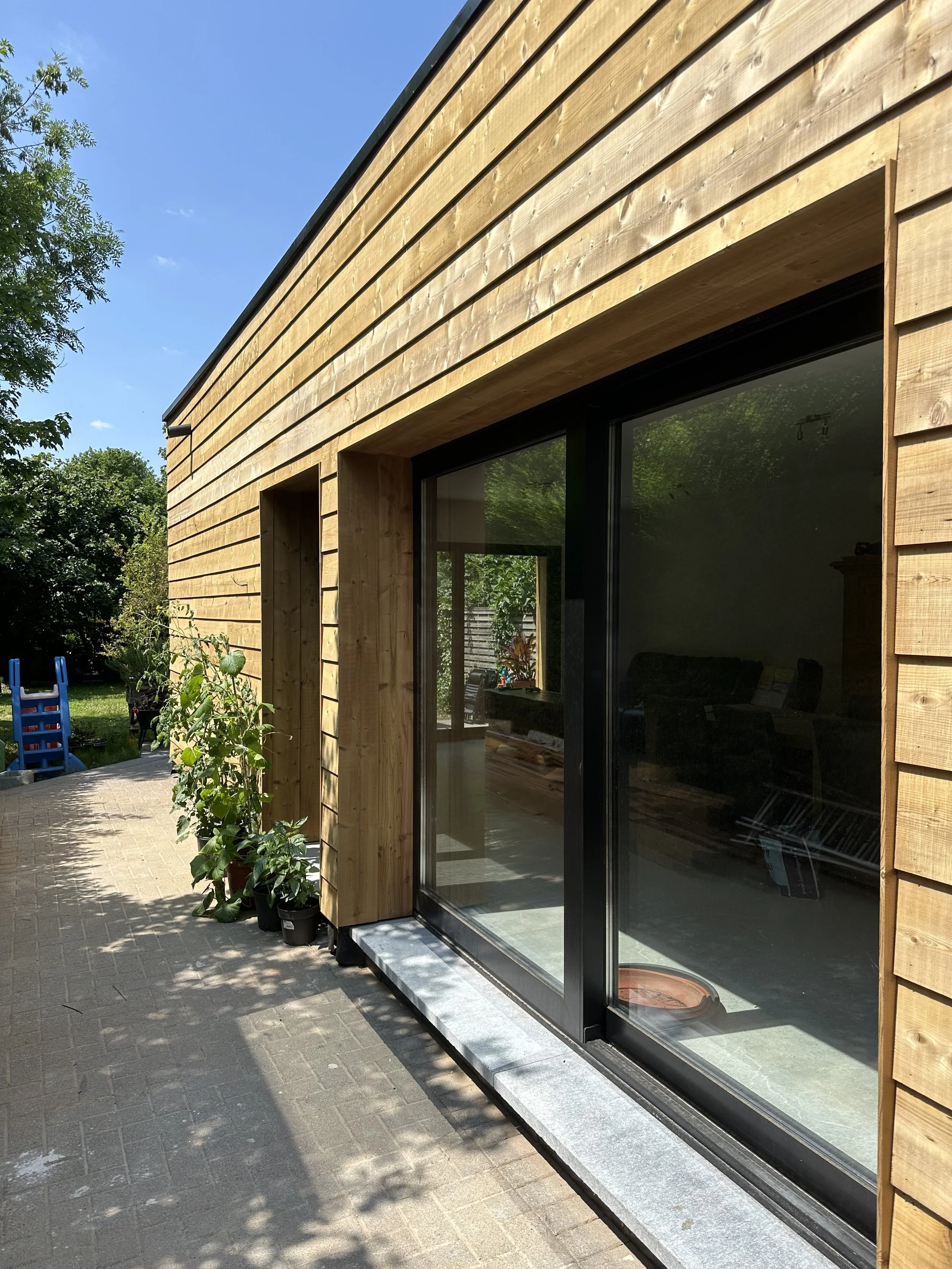 Houten gevelbekleding op maat met schuifraam, buitenschrijnwerk door Sorgeloose in West-Vlaanderen