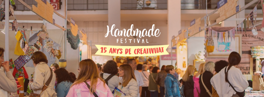 Festival de manualidades con muchas personas mirando puestos con productos artesanales en un entorno cerrado
