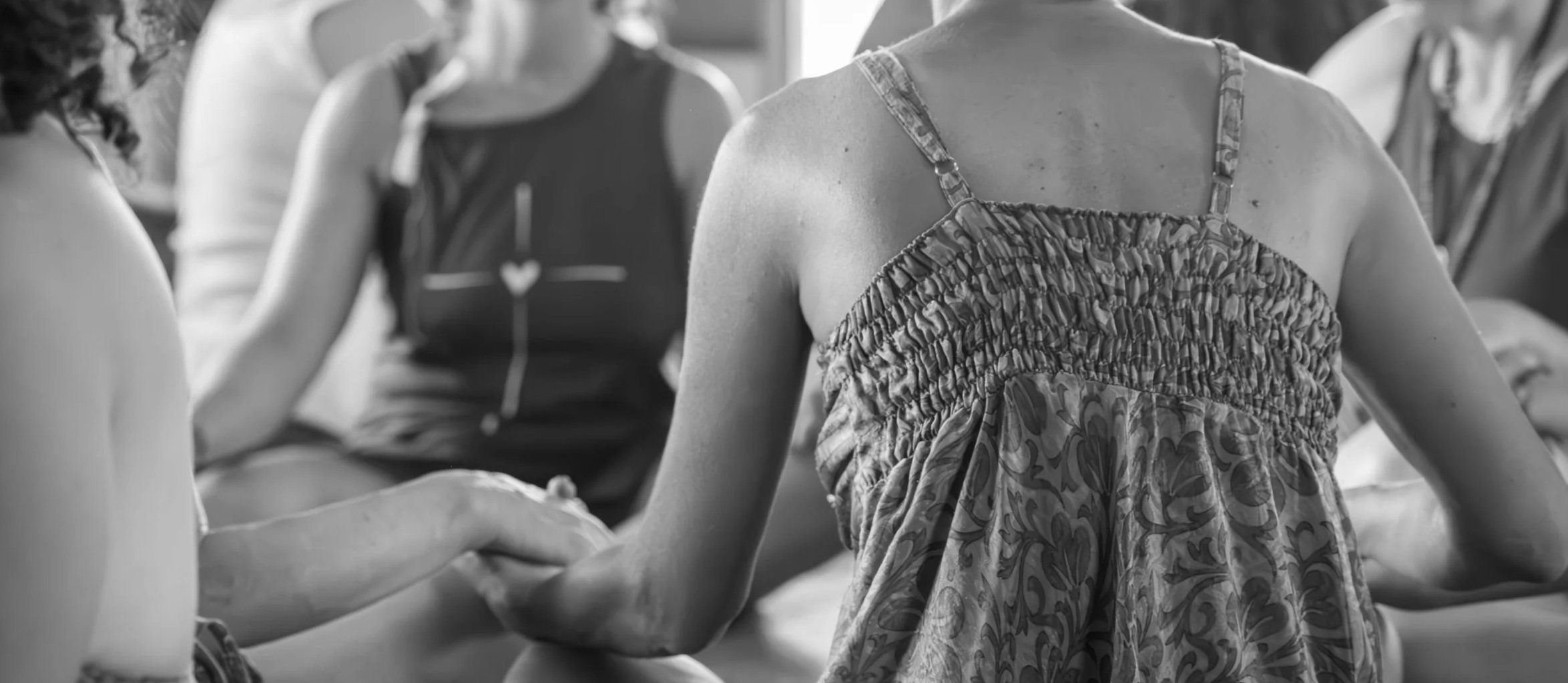 women  holding hands during a group sharing - women's circles with Valeria Alberigo