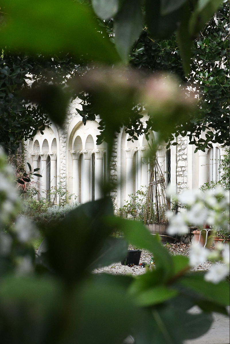 Une vue du jardin du restaurant la Courtille avec sa façade blanche et son style unique.