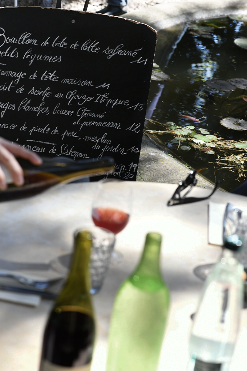 Une image proche de la fontaine de la Courtille avec la carte et un table au déjeuner.