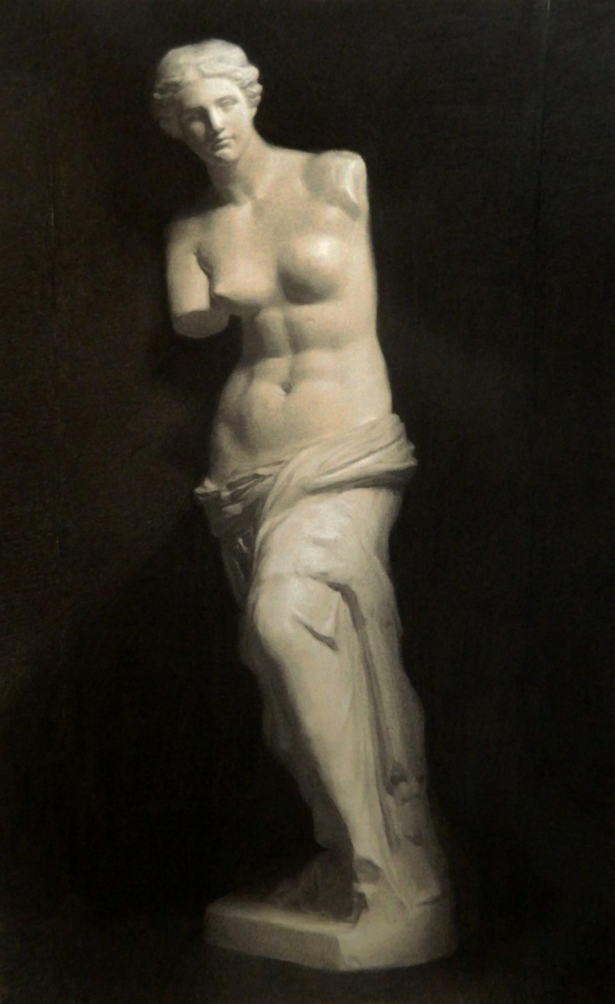 Marble sculpture of the venus, displayed against a dark background.