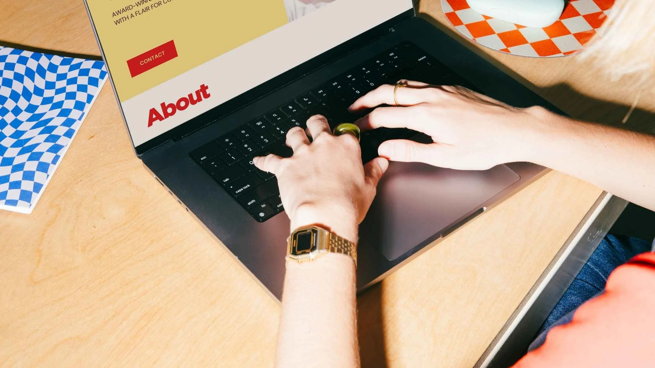 A close up of a woman's hands creating an About page on a website
