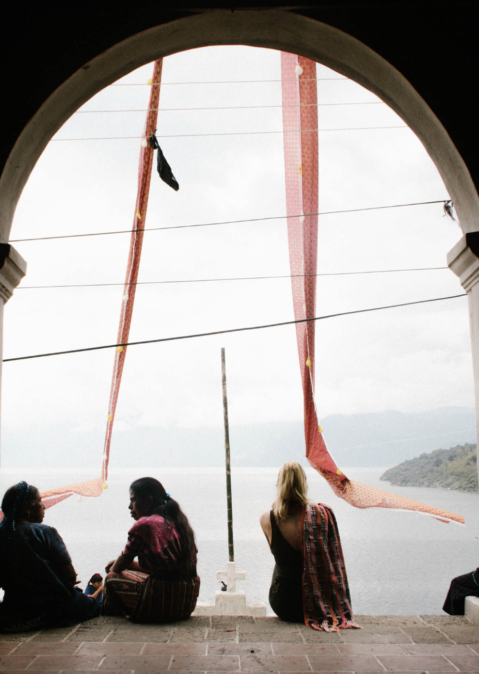 Cross-cultural exchange between women overlooking Lake Atitlán in Santa Catarina Palopó, Guatemala.