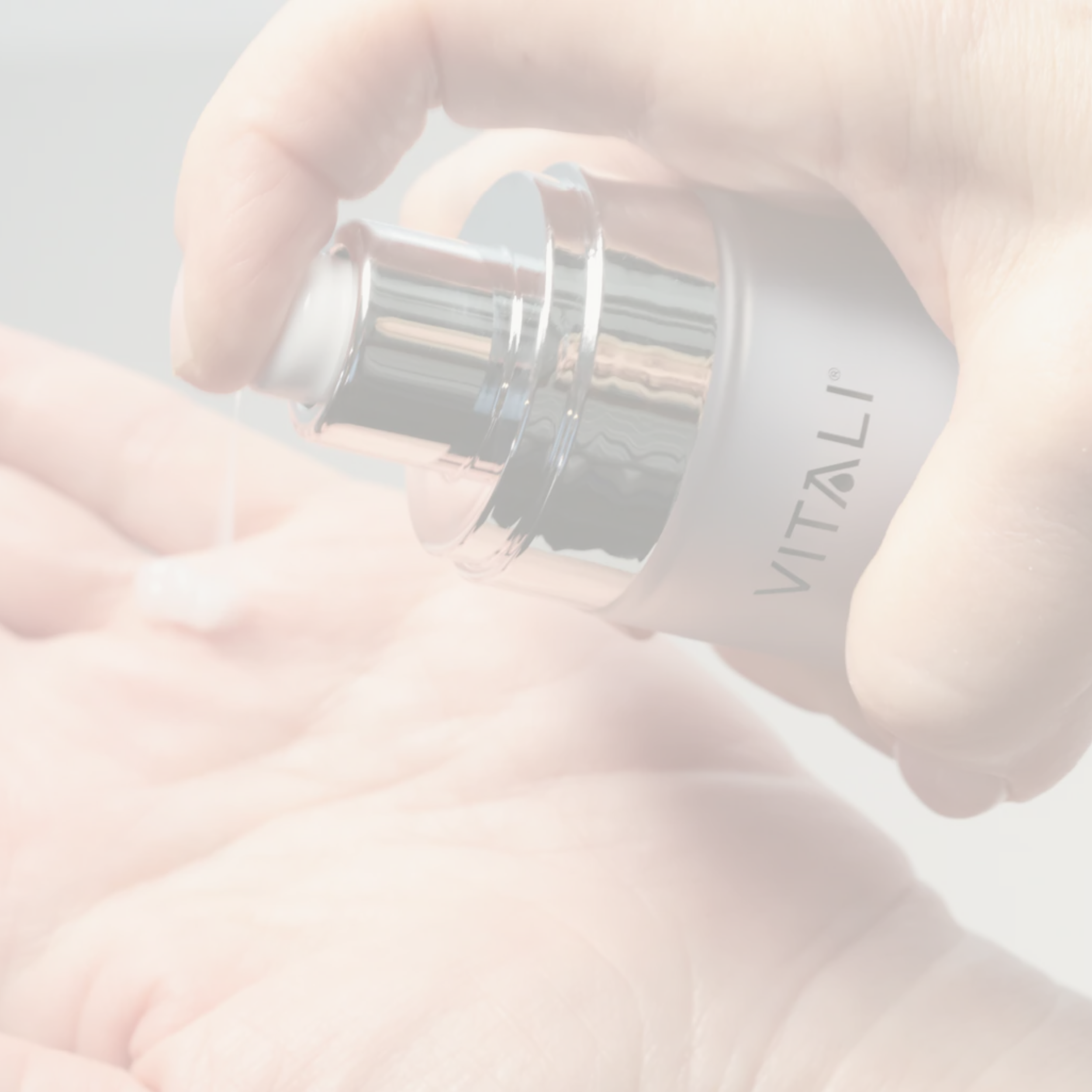 Close-up of a hand holding a bottle of Vitali Skincare.