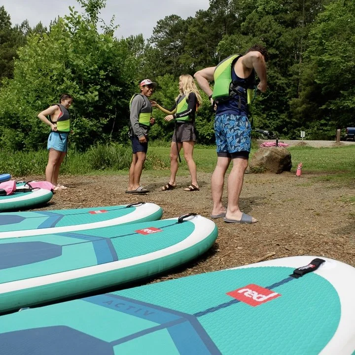 Zephyr guide preparing a small group for a paddleboard tour on Mountain Island Lake