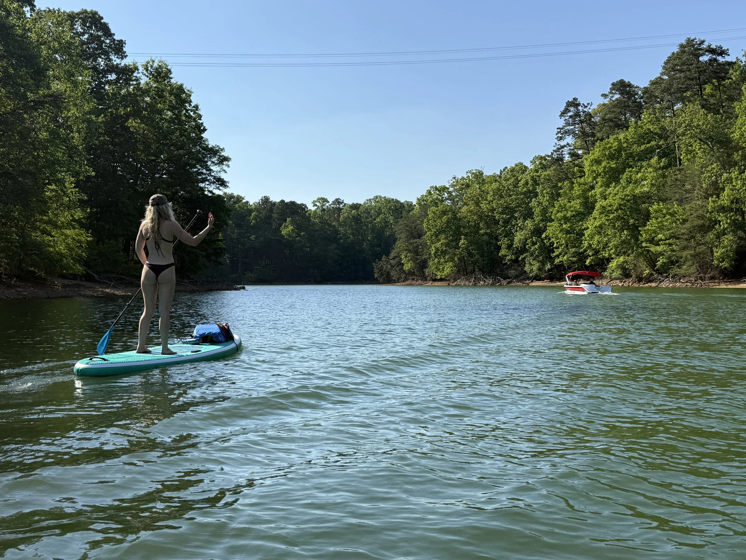 Woman paddleboarding on Lake Norman with Zephyr Paddlesports SUP rental