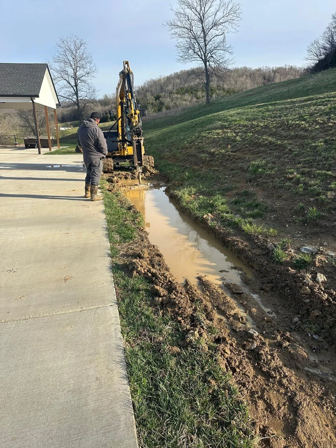 Breaking through hardpan to get this drainage trench where it needs to be. Some ground doesn't move easy.