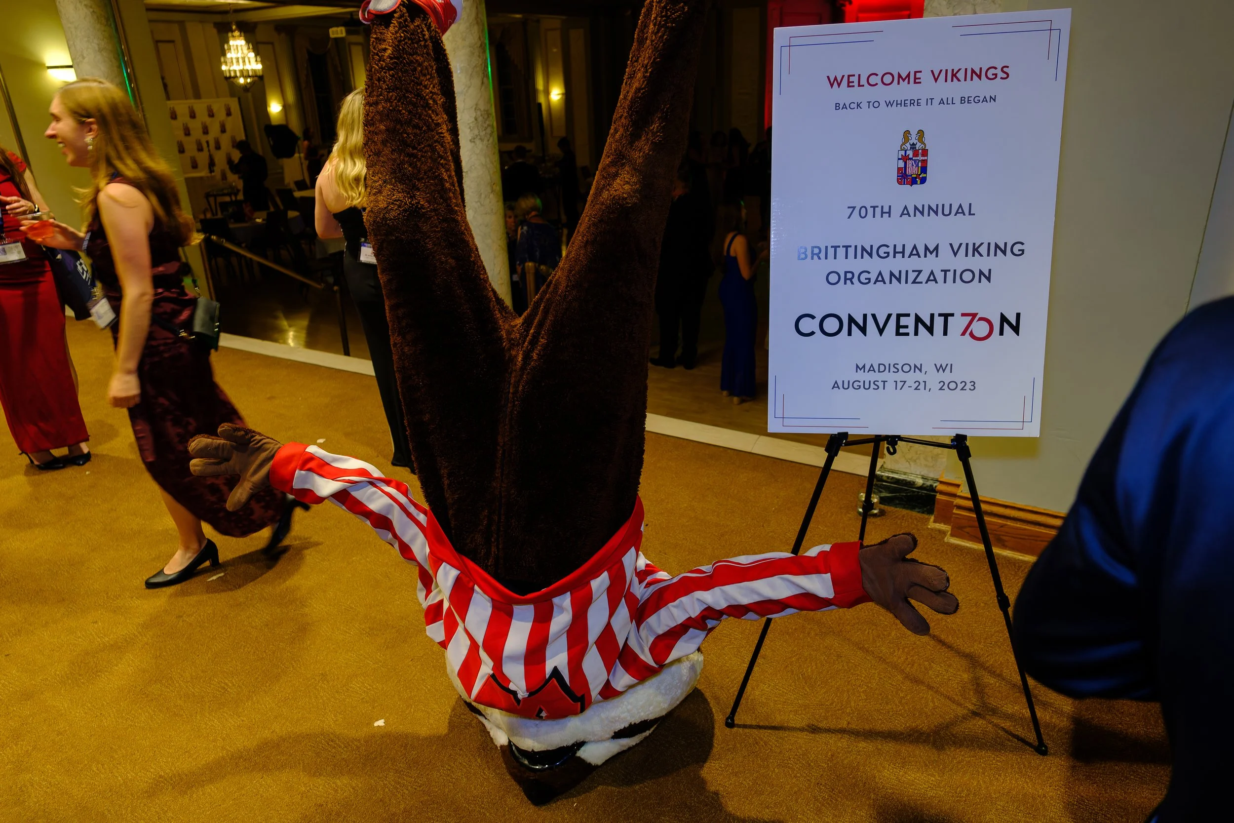 Bucky Badger balances on his head next to a sign for the Brittingham Viking Organization's 70th annual convention in Madison, Wisconsin.