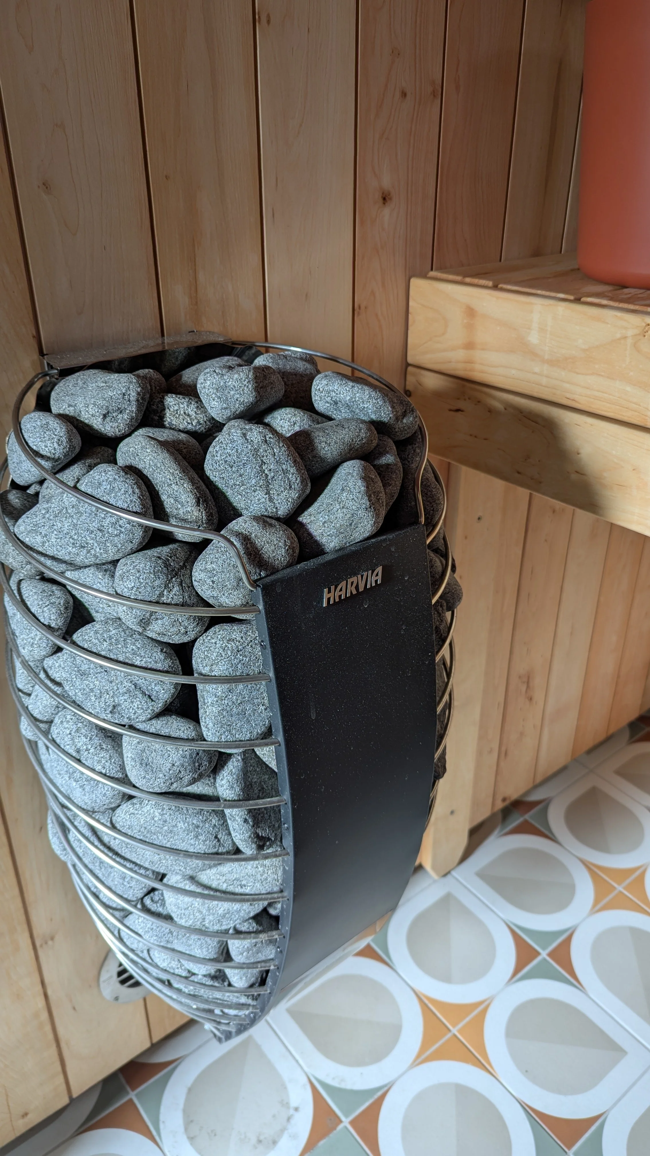 En kurv med svarte steiner plassert ved en vegg og et lite bord.