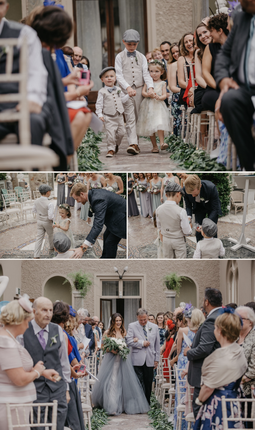 A wedding ceremony in a courtyard with children walking down the aisle, a groom accepting rings from a young boy, and a bride holding a bouquet and walking down the aisle, surrounded by guests in formal attire.