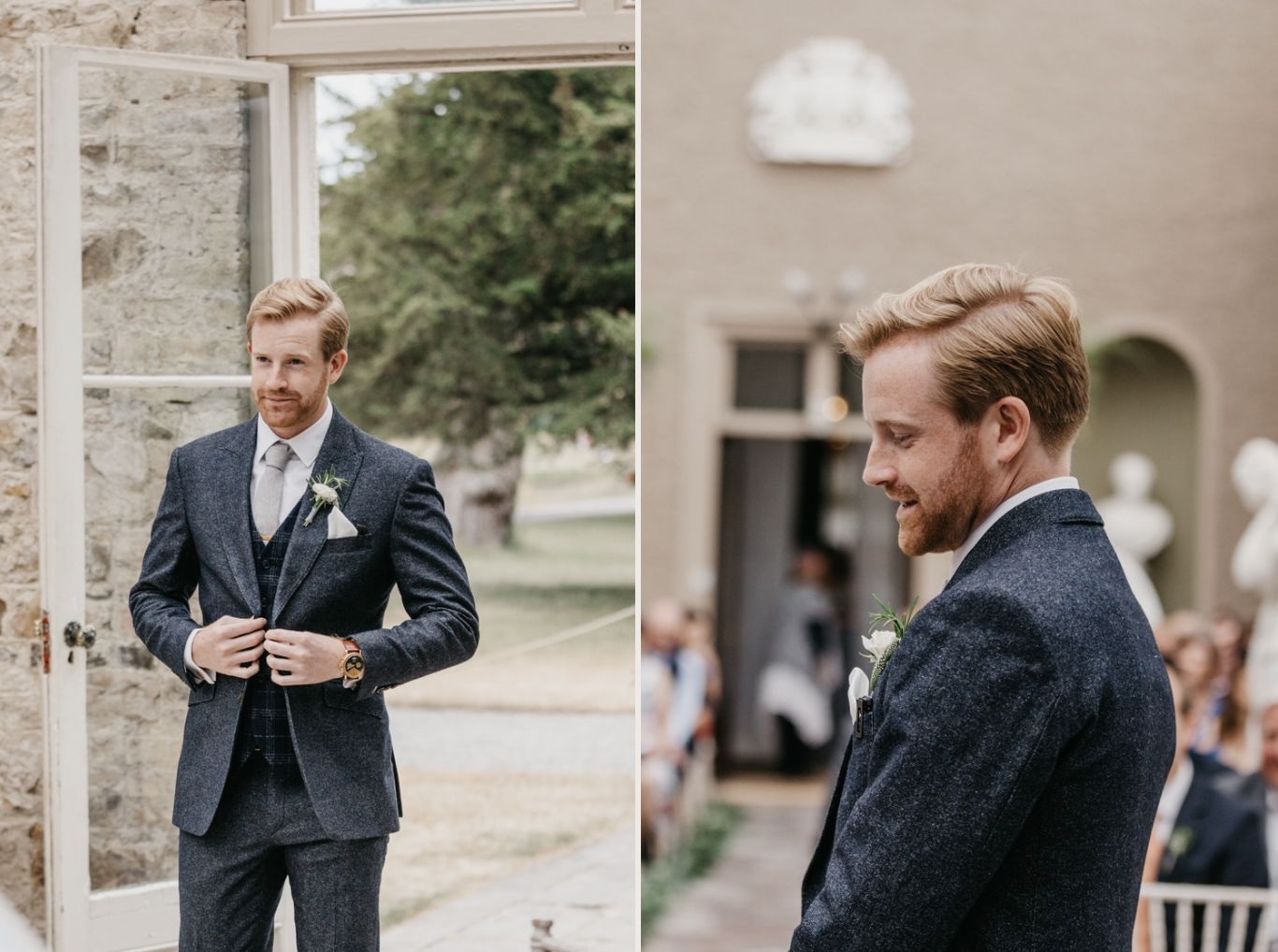 A groom in a dark gray suit with a white shirt and light gray tie, standing outside and adjusting his suit jacket, with a plaid vest underneath. He has light brown hair and a beard. The background shows a stone wall, open window, and outdoor greenery