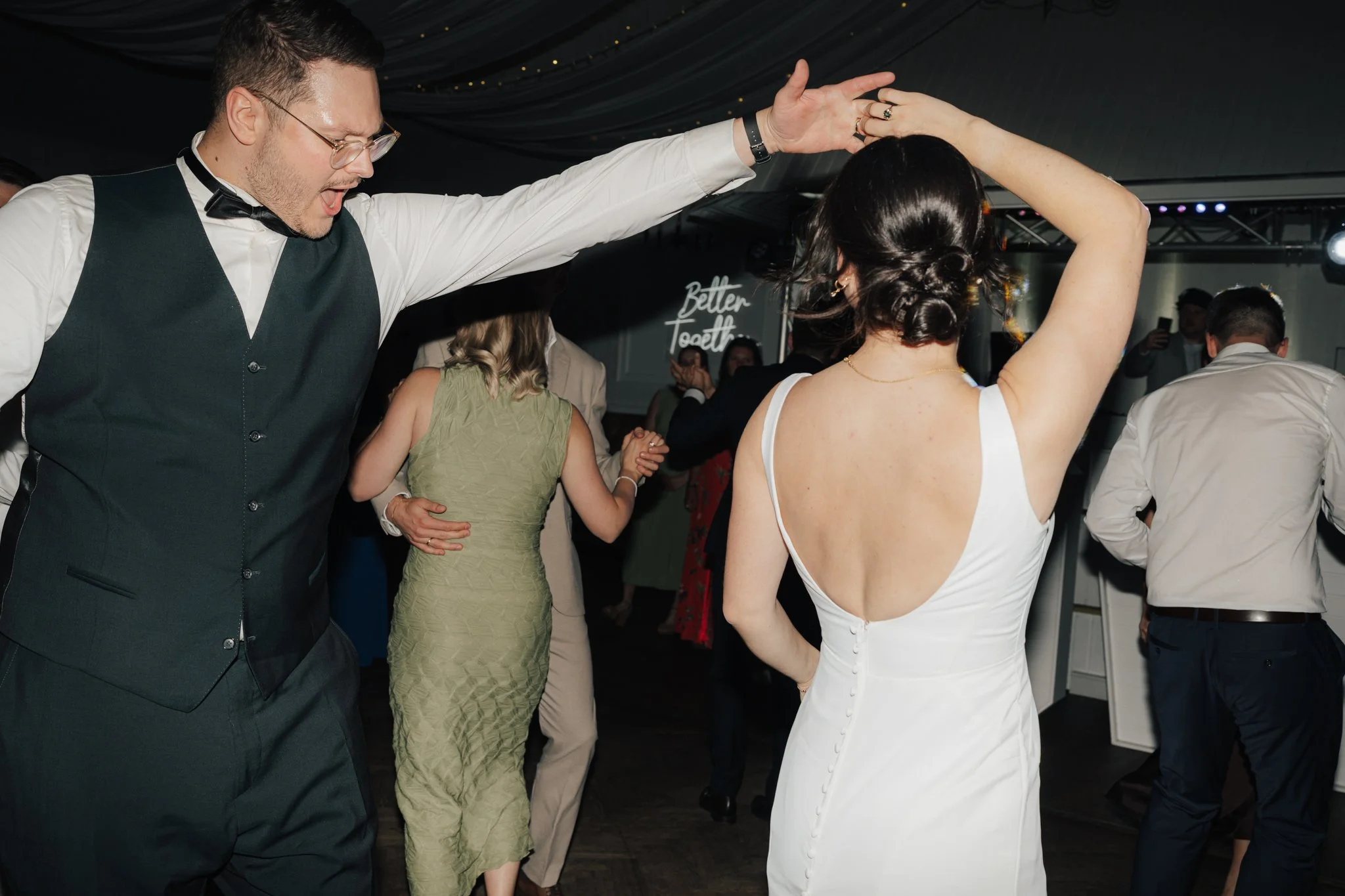 Paare tanzen auf einer festlichen Veranstaltung in einem festlich dekorierten Raum.