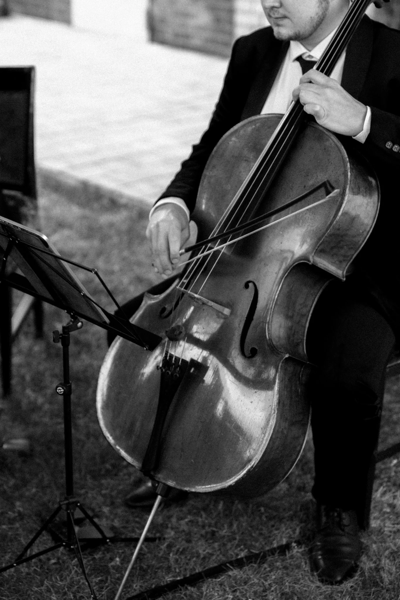 Ein Mann in einem Anzug spielt Geige in Schwarz-Weiß-Foto.