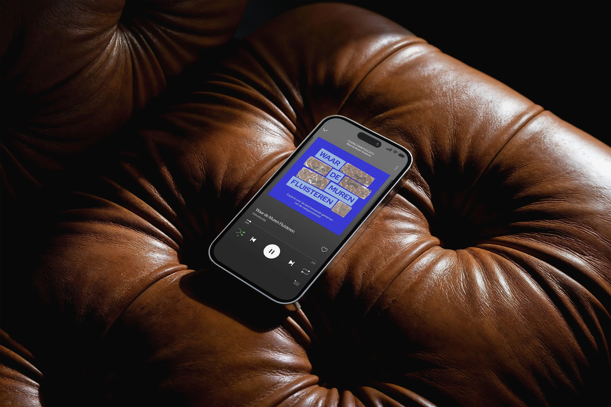 Podcast playing on phone, laying on leather couch