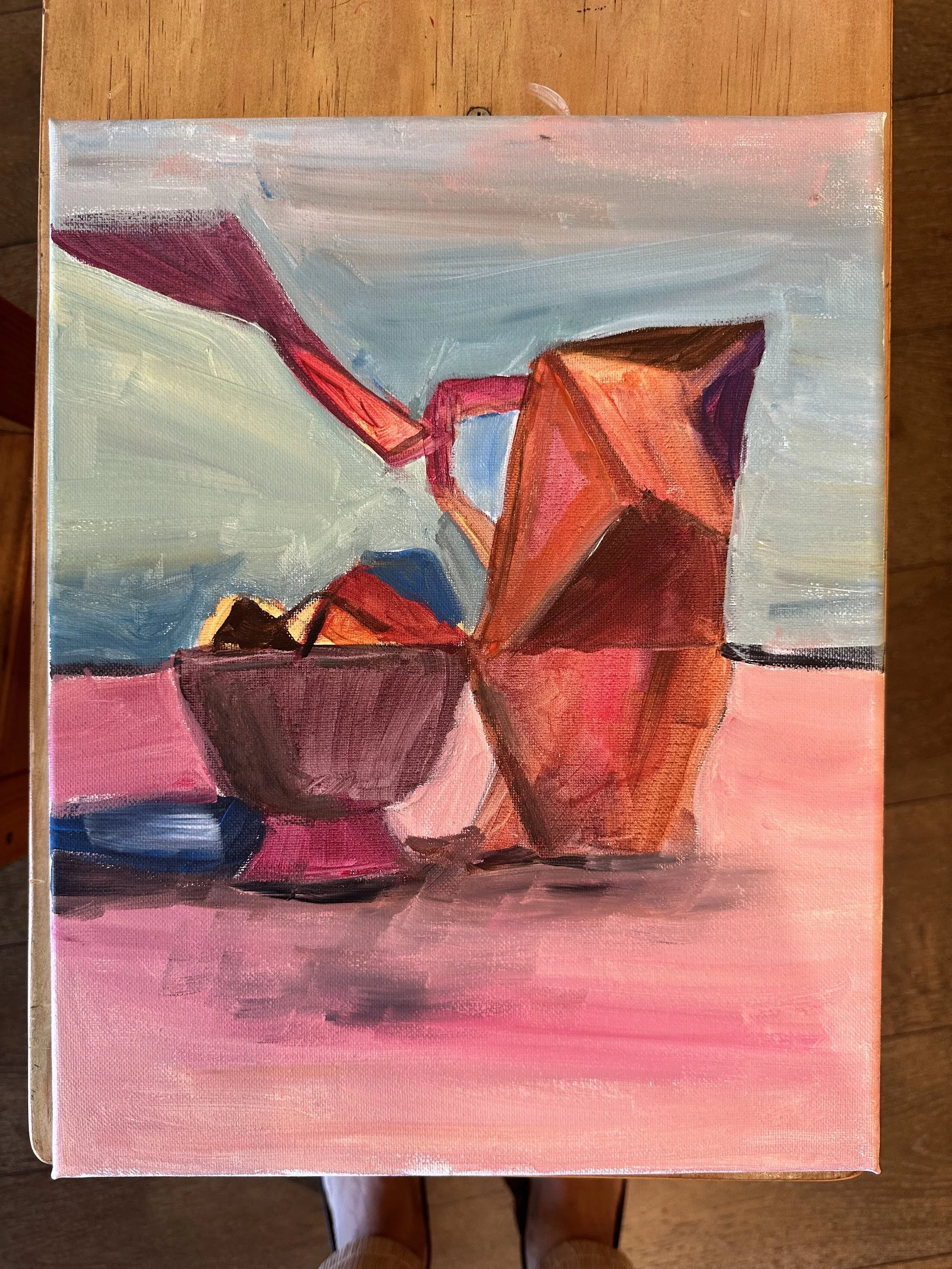 A still life painting depicting a bowl of fruit and a paper bag on a pink surface with a light blue and pink sky background.