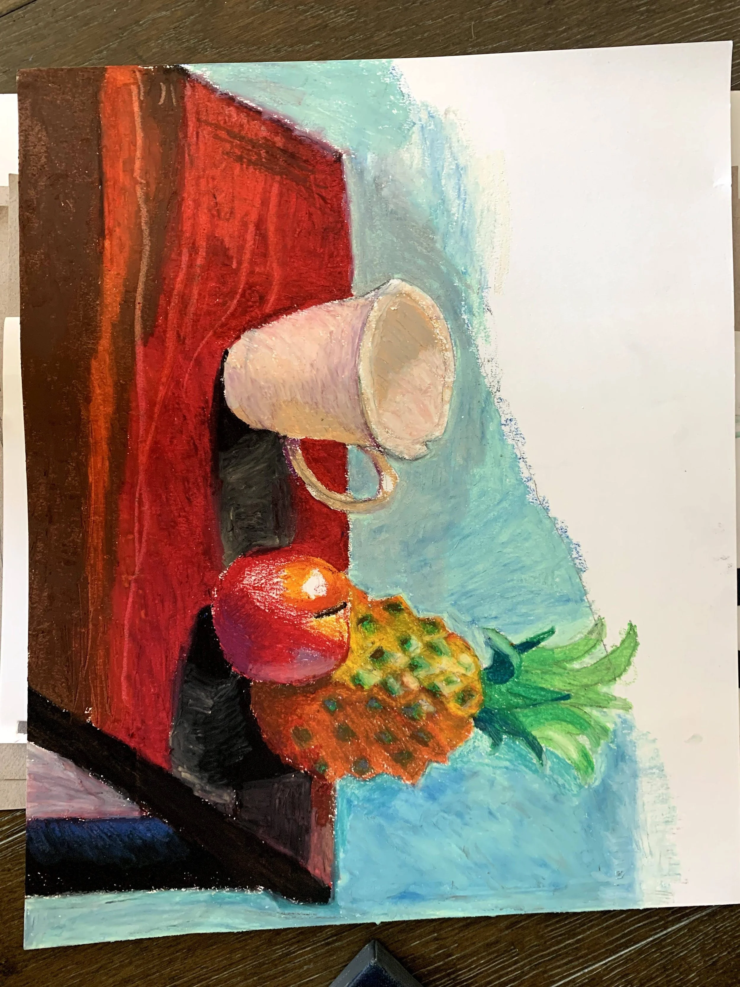 A colorful still life painting featuring a red box, a beige cup, an apple, a pineapple, and a bunch of green leaves on a blue surface.