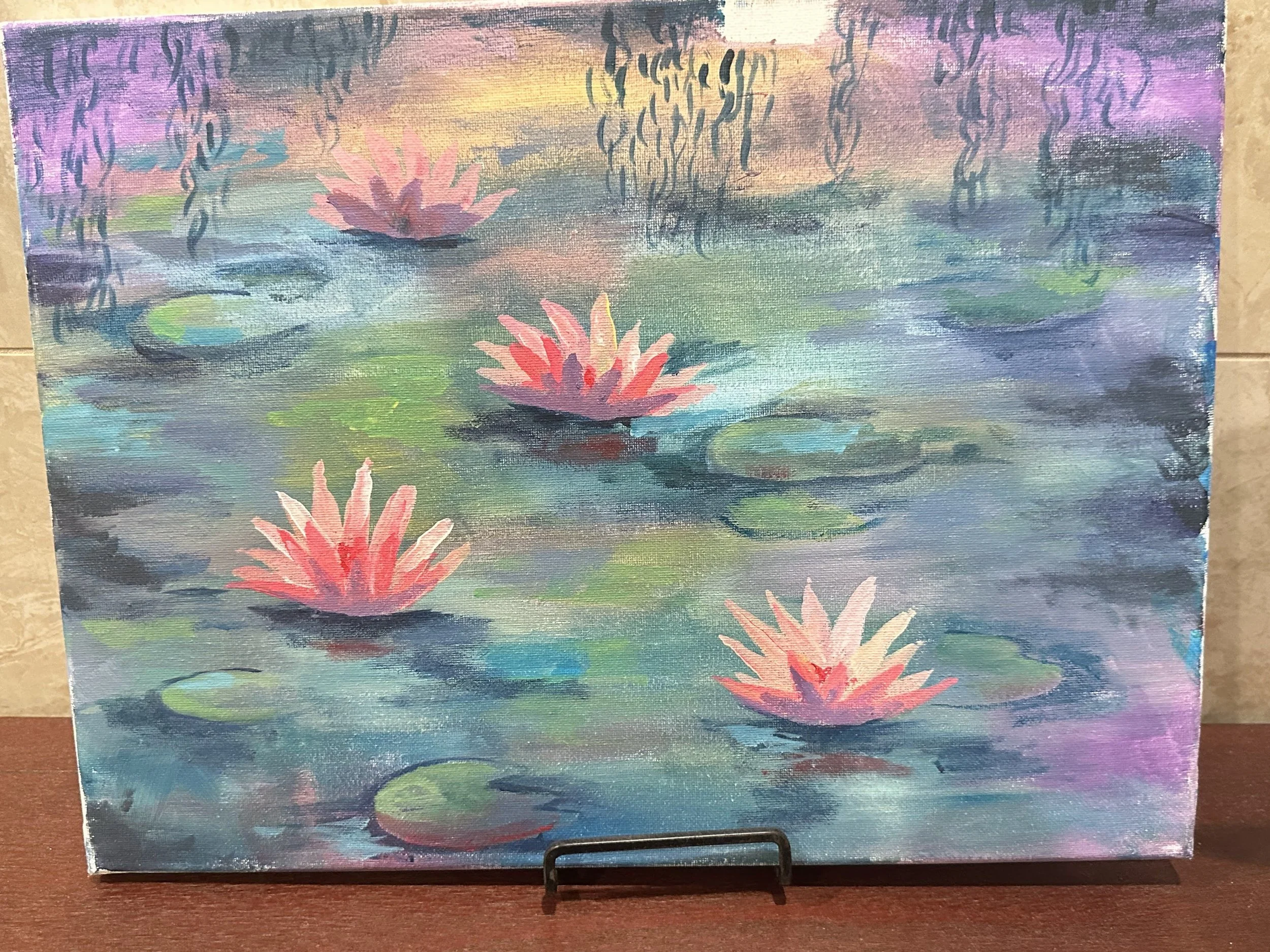 A colorful painting of water lilies on a pond, with pink lilies floating on the water and lily pads, captured in soft pastel hues.