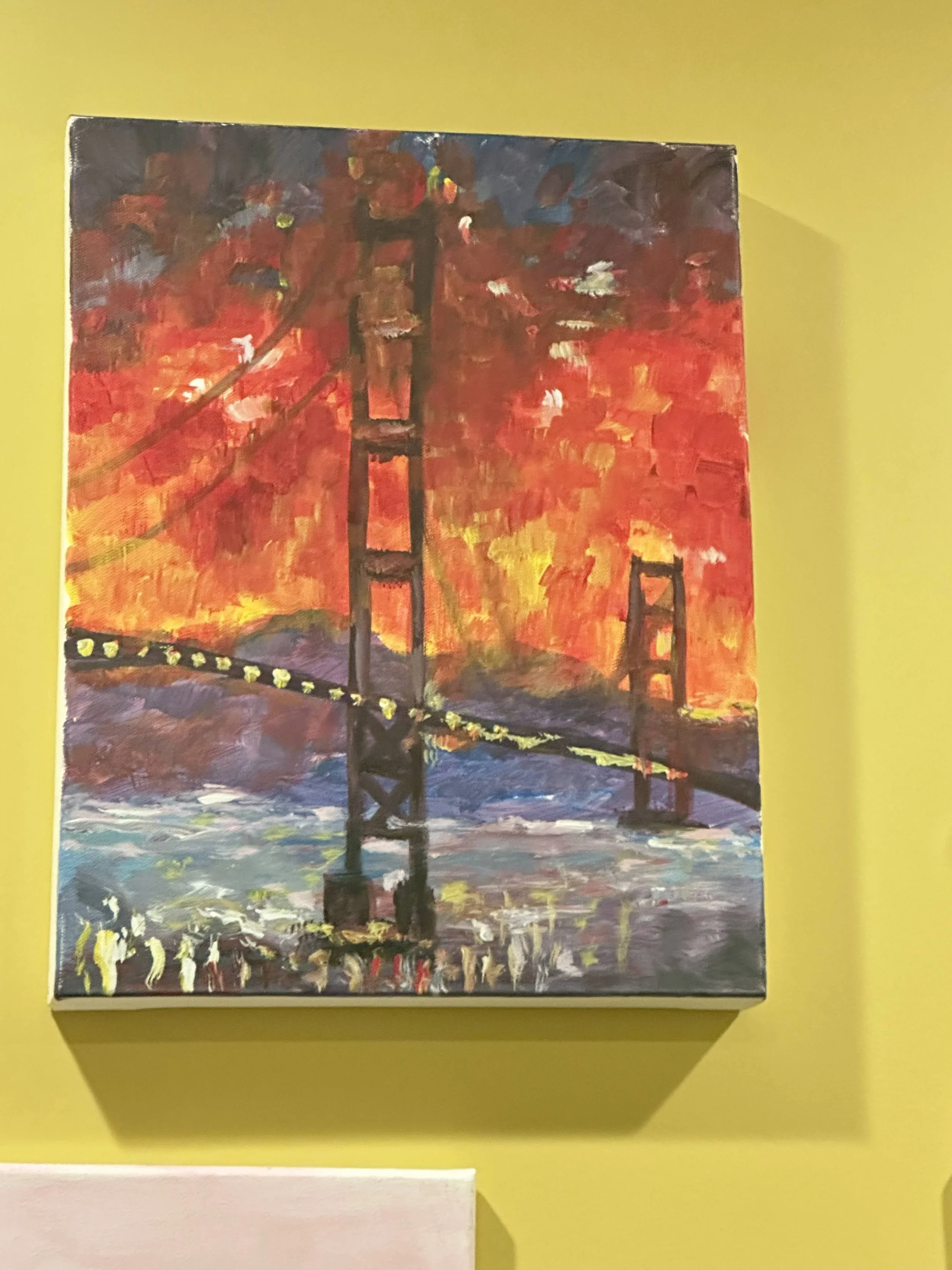 Painting of the Golden Gate Bridge during a sunset with a fiery red-orange sky in the background.