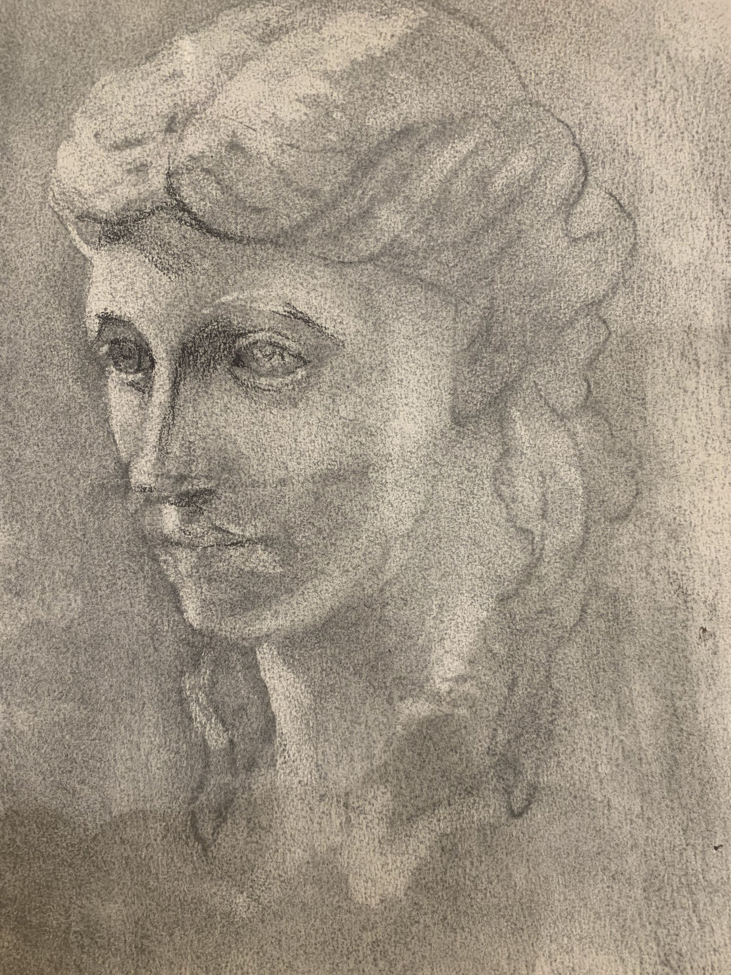 A detailed pencil sketch of a woman's face with wavy hair, showing her eyes, nose, and lips in profile.