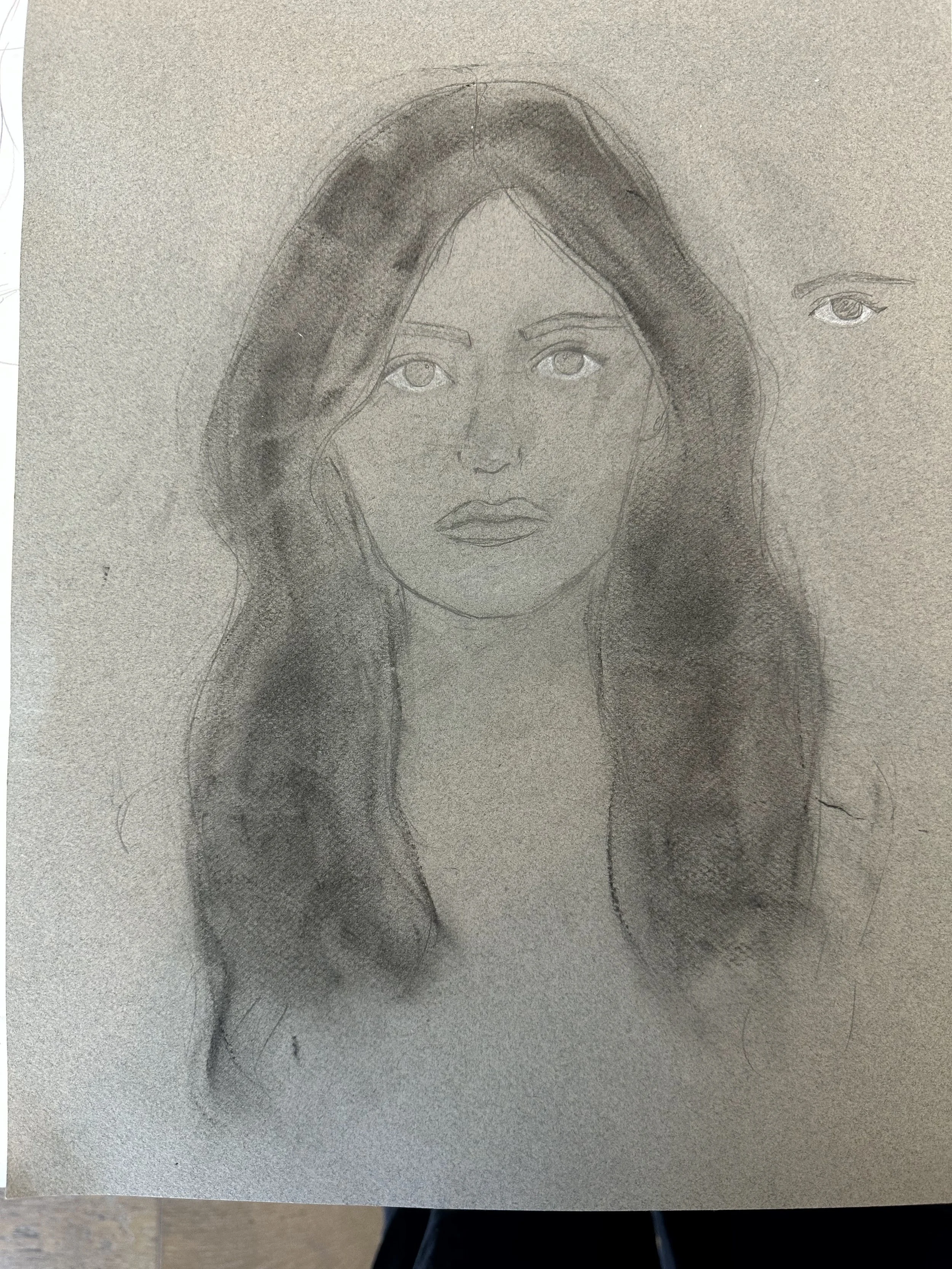 A pencil sketch of a woman with long, wavy hair, featuring detailed eyes and lips, and an additional smaller eye sketch to the right of her face.