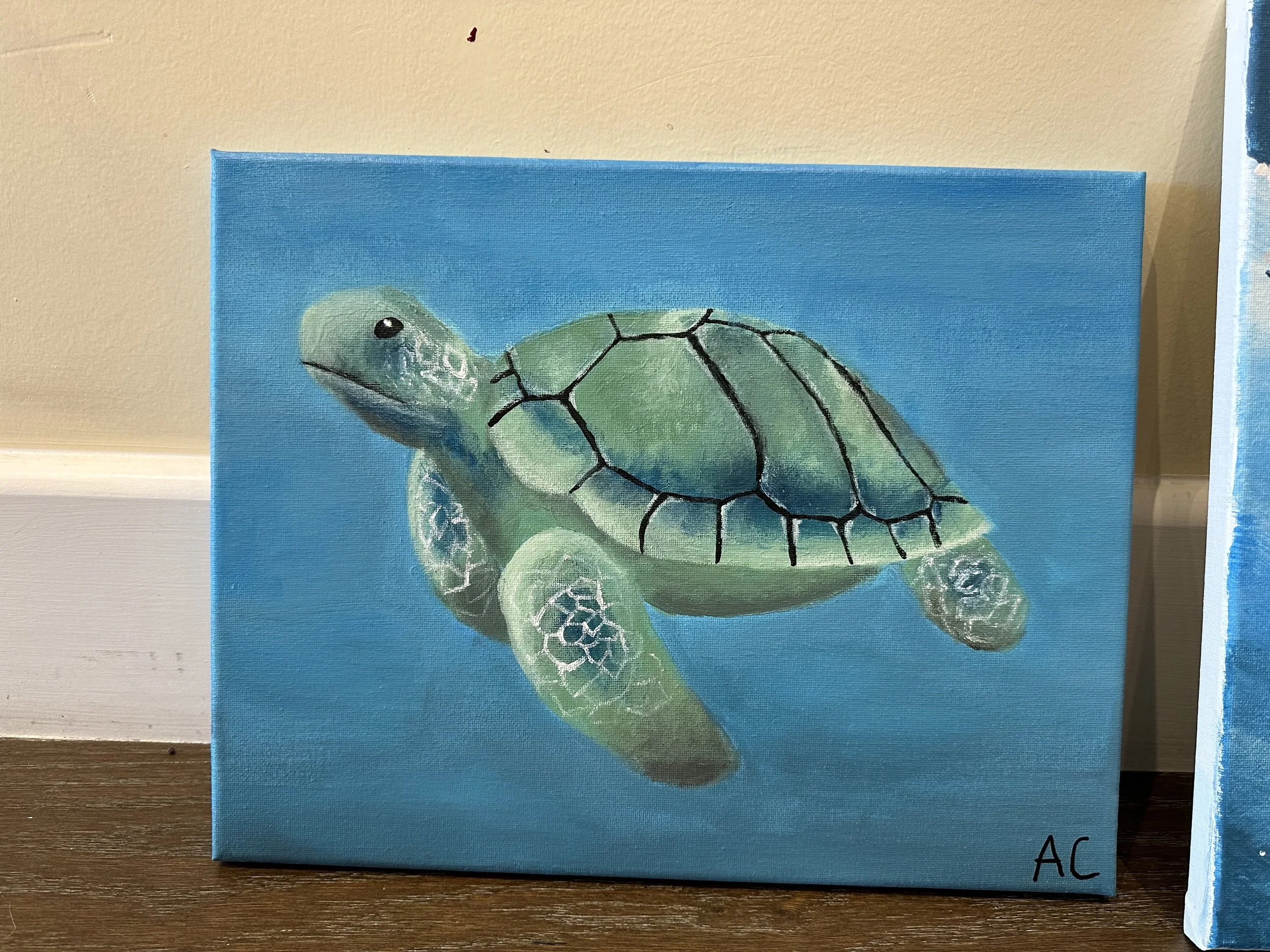 Painting of a green sea turtle swimming underwater with a blue background, signed with initials "AC" in the bottom right corner.