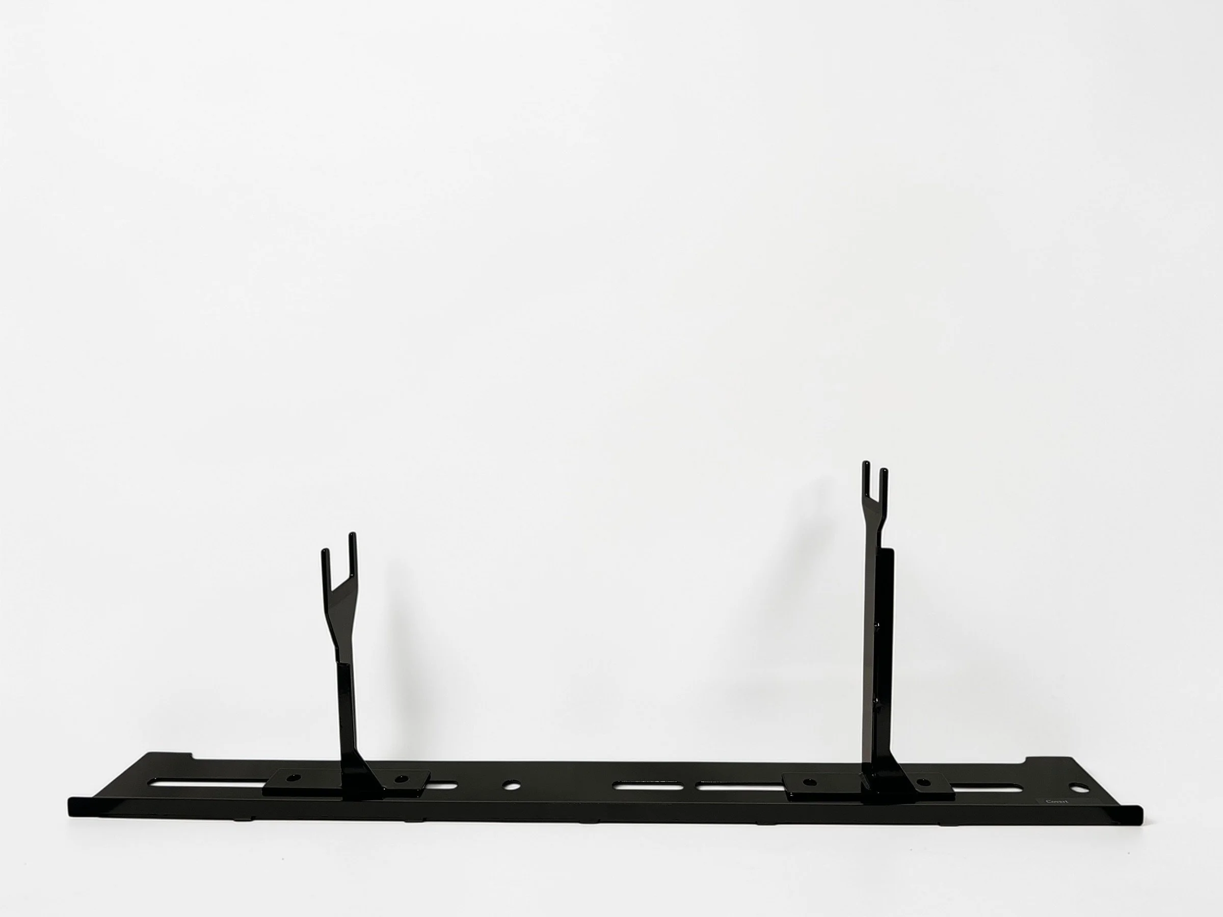 Black metal object with two adjustable prongs on a flat base against a white background.