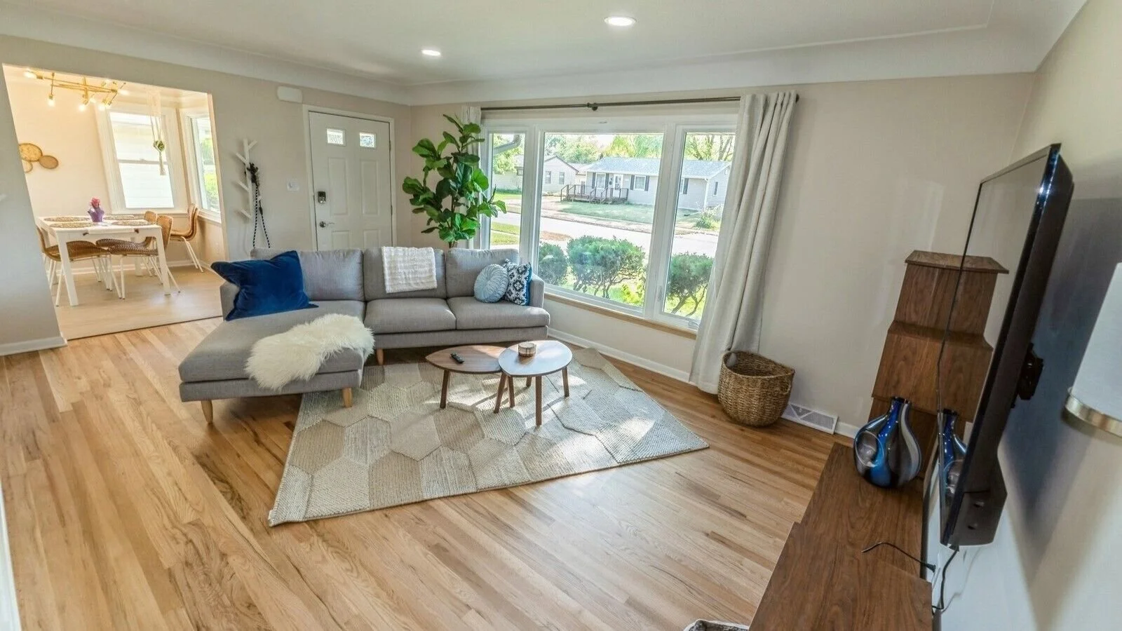 Bright open living room. Comfortable space to relax. New leather swivel chair not pictured.