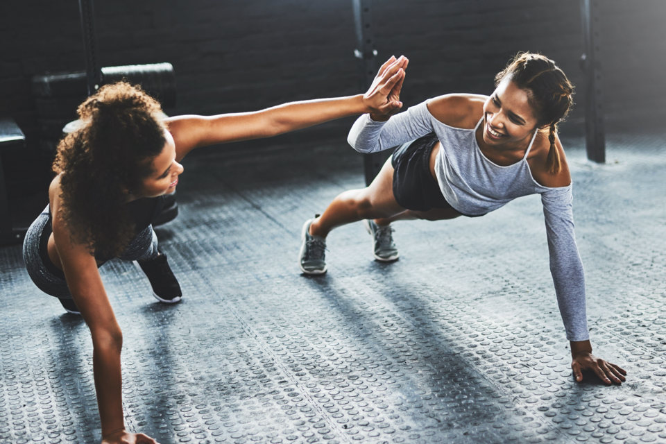 two females doing push ups together group training surrey