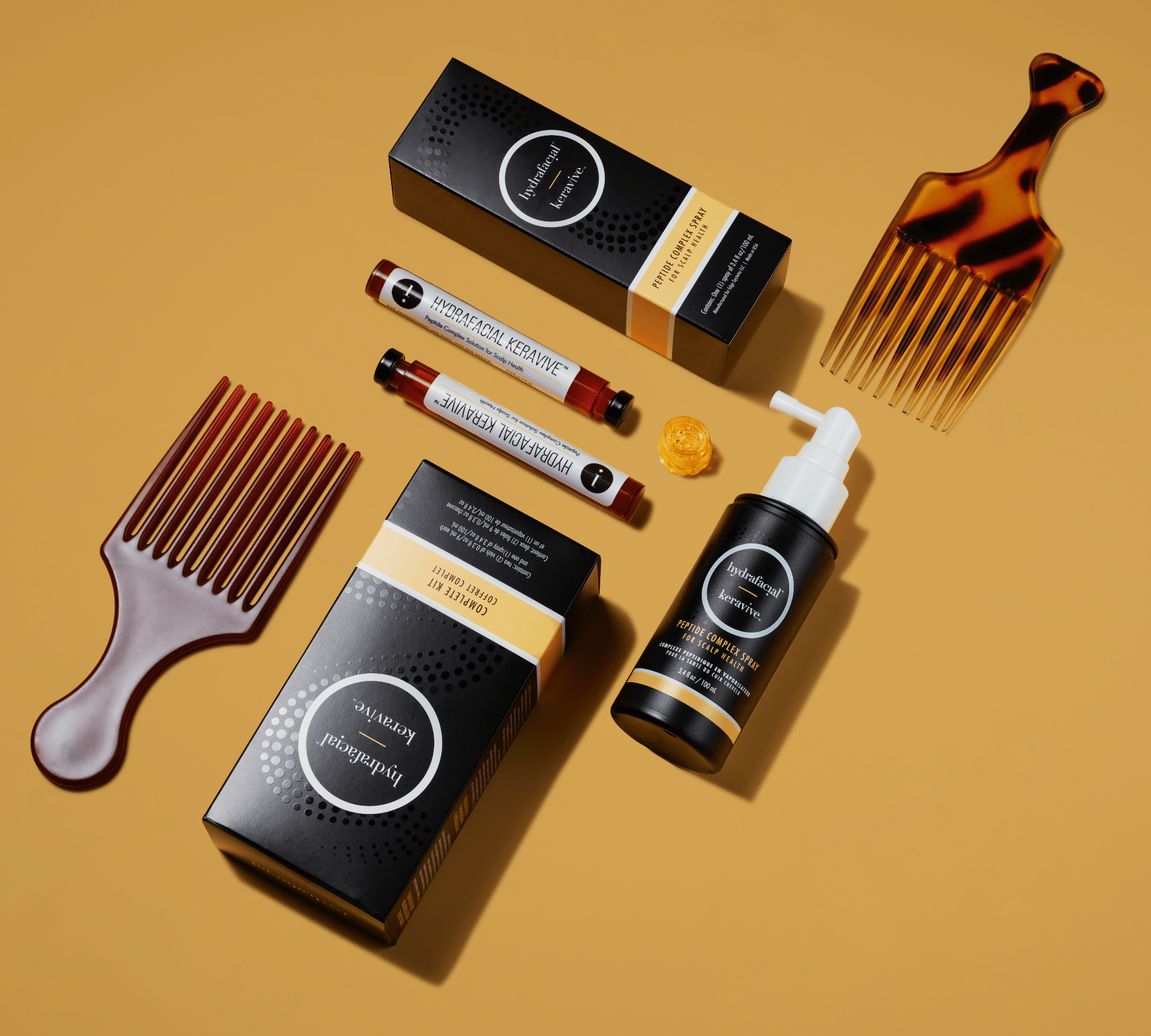 Productos para cuidado del cabello, incluyendo spray, sérum, y peines, en una superficie amarilla.