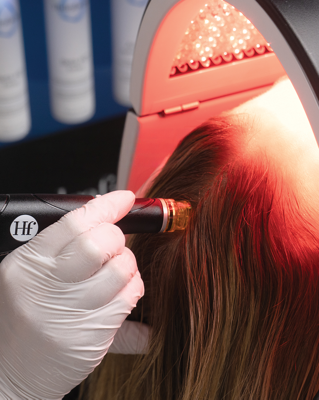 Tratamiento capilar con lámpara de luz infrarroja en cabello de mujer.