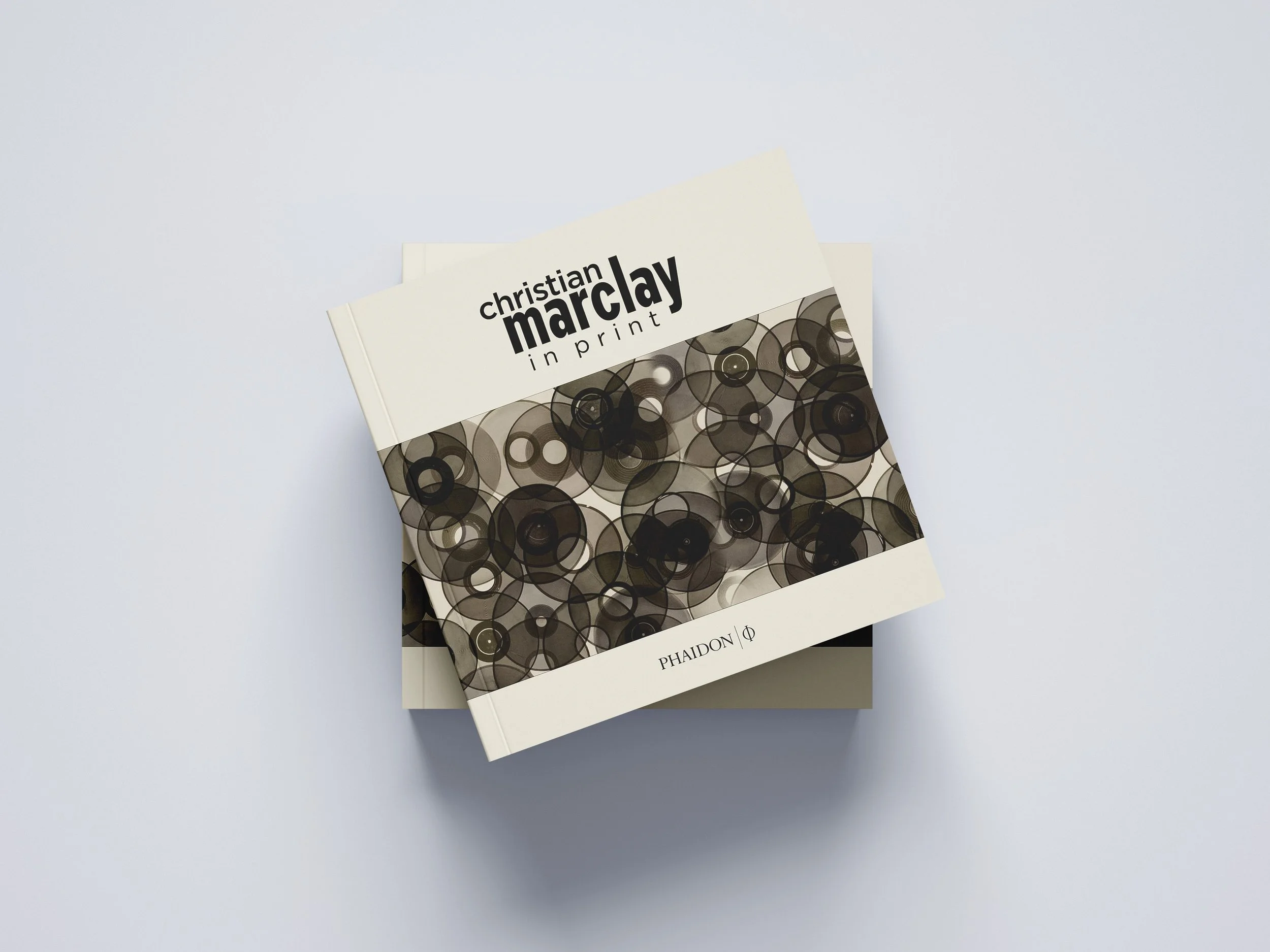 Book titled 'Christian Marclay in Print' with a cover design featuring overlapping black and gray circles, published by Phaidon.