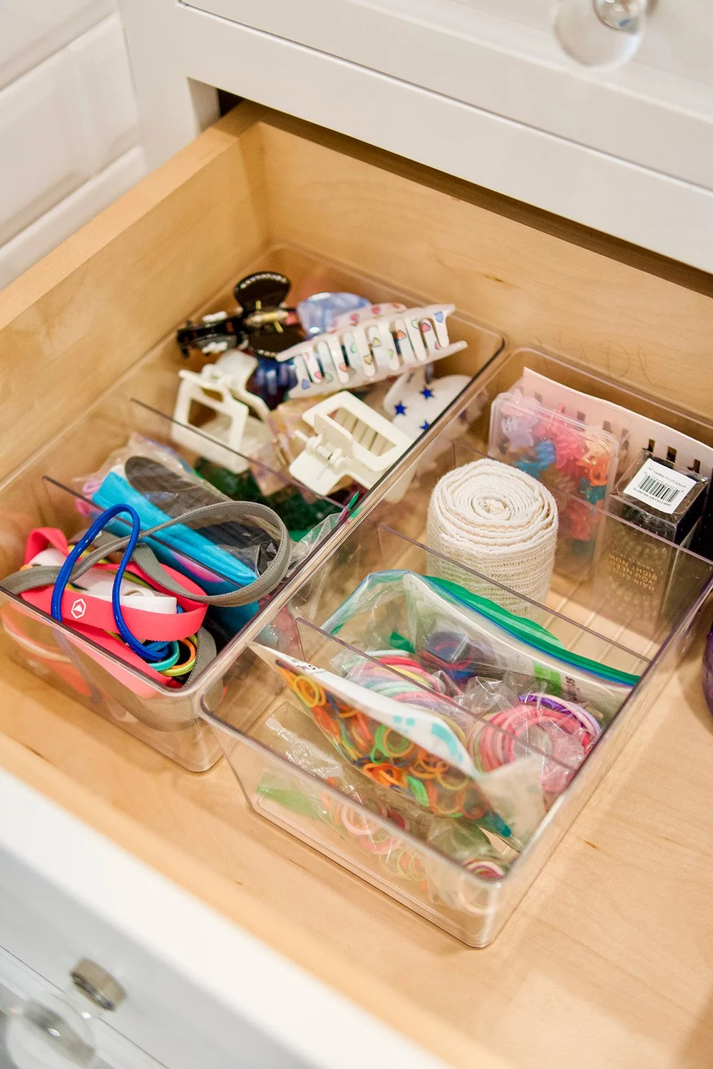 Organized drawer containing hair accessories, hair ties, scrunchies, clips, and hairbands.