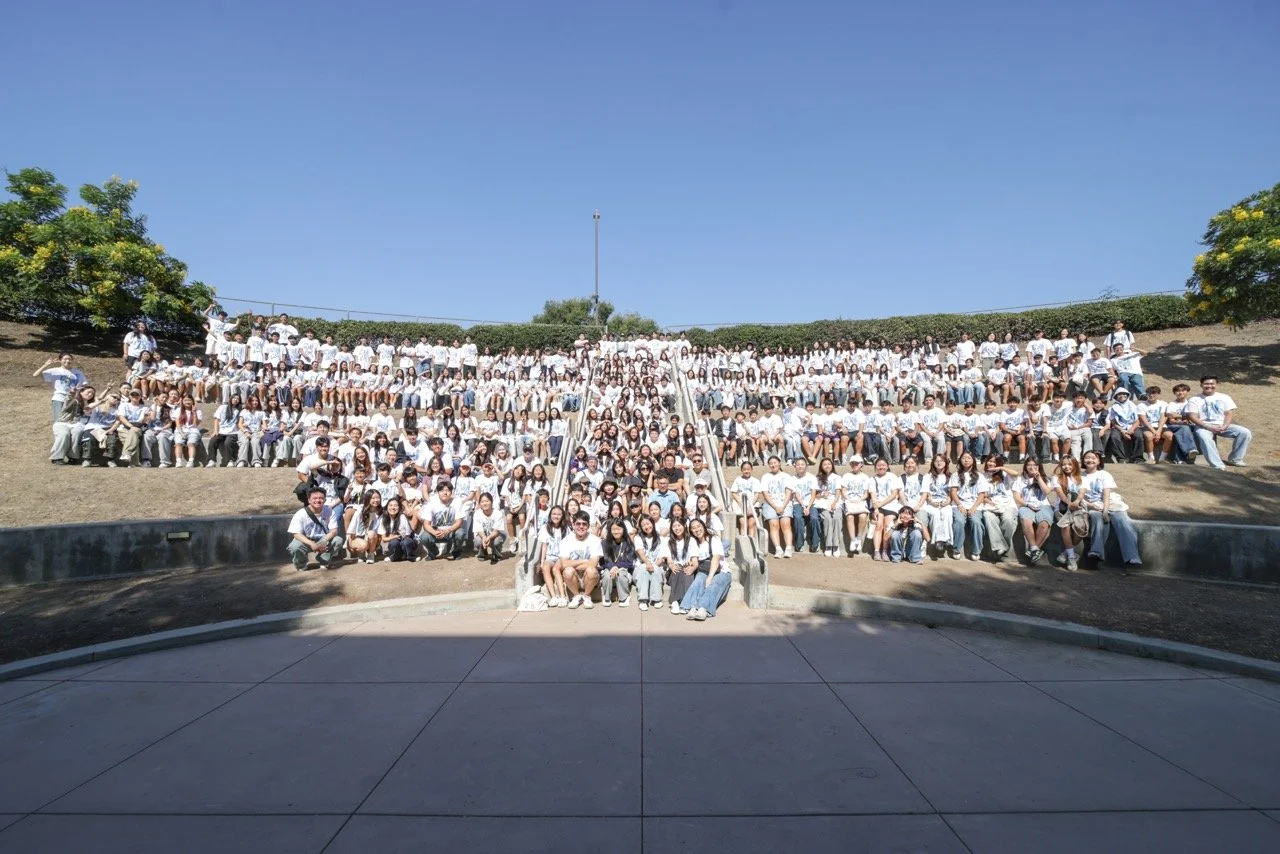 Large group of people, mostly young adults, sitting on outdoor tiered steps on a sunny day. This is from our annual Summer Camp hosted at Biola University in La Mirada, CA.