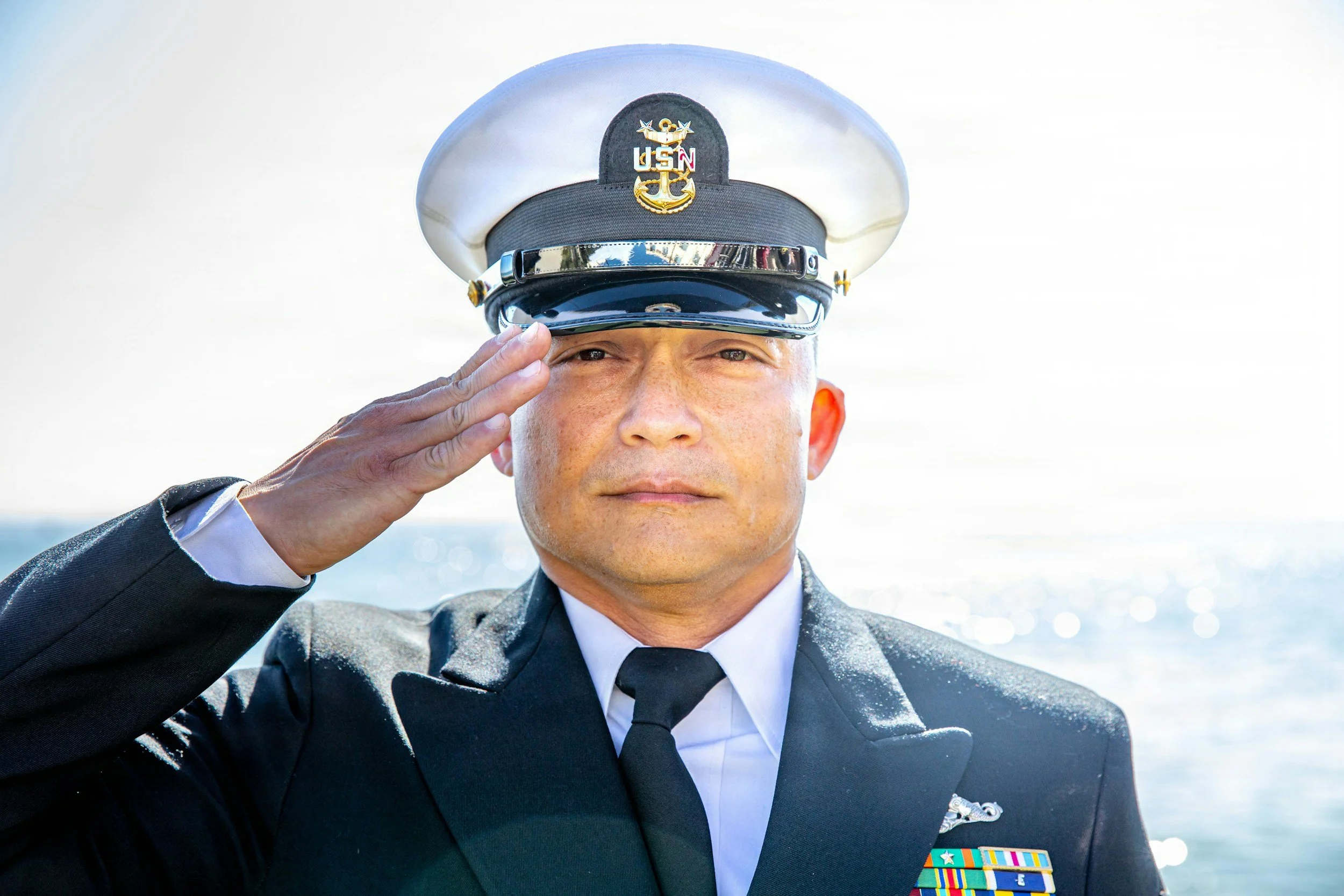 US Navy officer saluting representing veterans and military service members who qualify for SSDI disability benefits through Catwig LLC