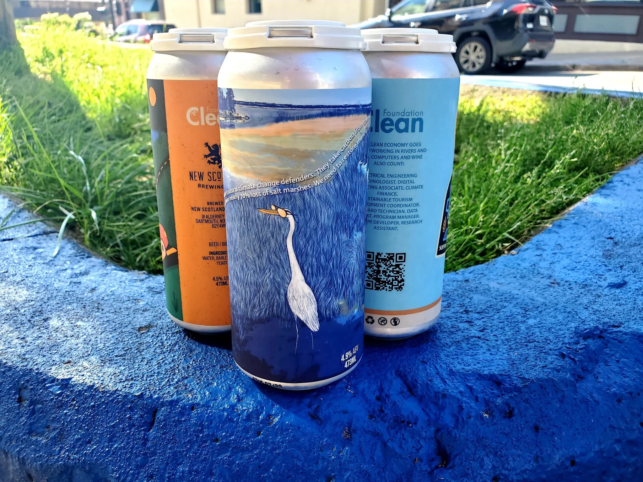 Three cans of beer on a curb outside