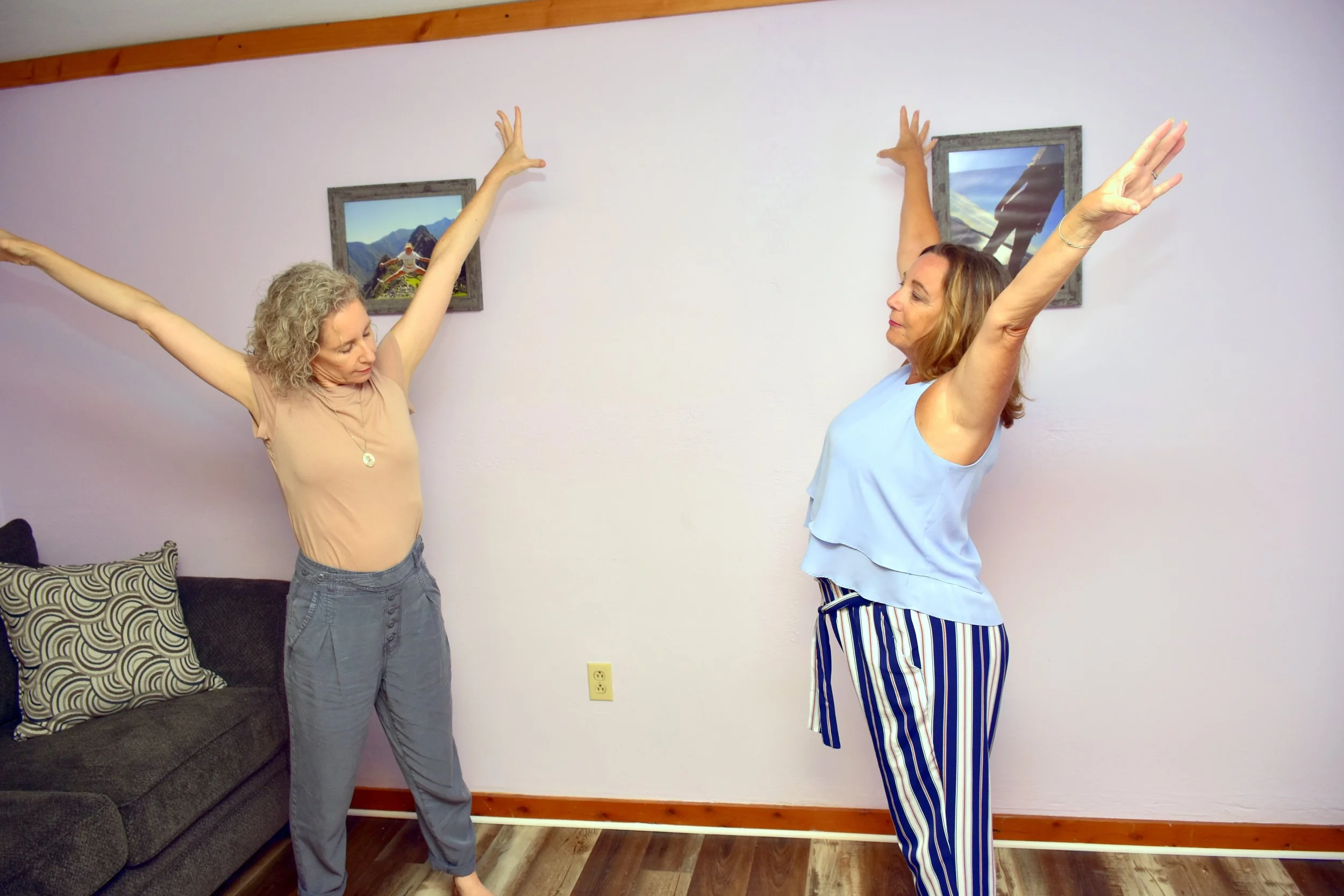 Melissa reflecting a woman's movement of having her hands raised high in the air as an example of dance/movement therapy