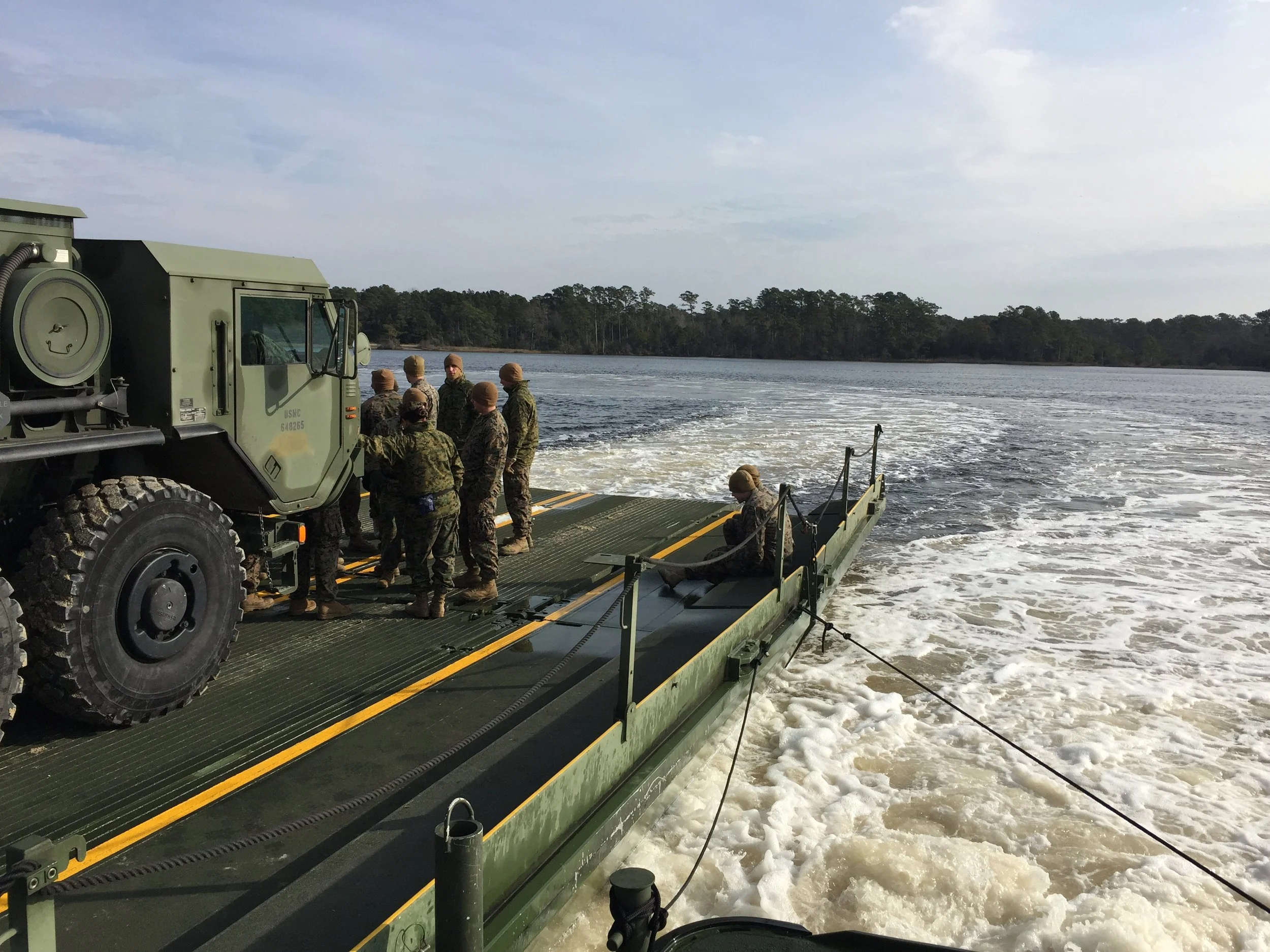I'm supervising river rafting operations, transporting this military vehicle across a small inlet.
