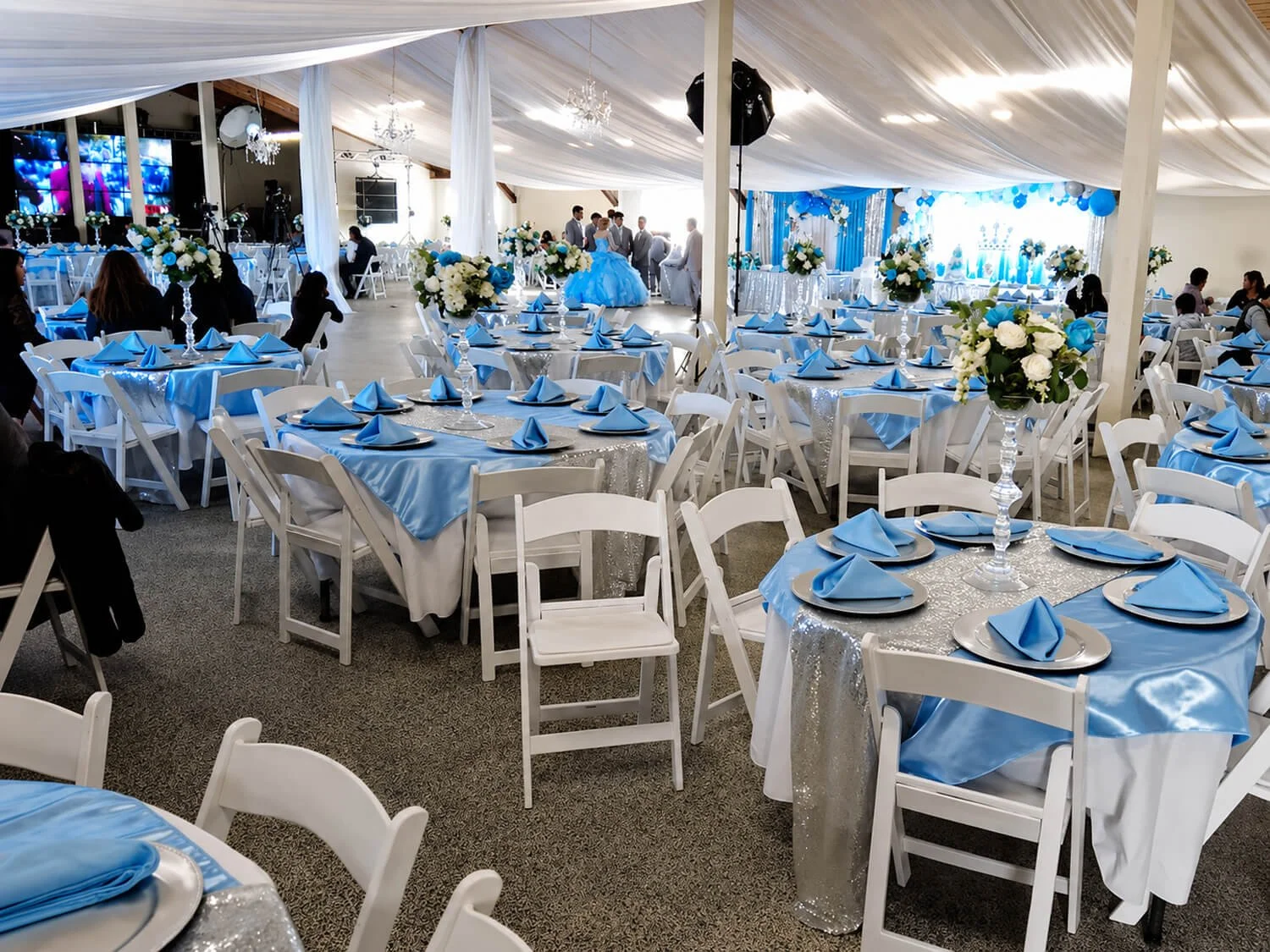 Back Hall quinceañera setup at the FDES Portuguese Hall of Monterey with decorated tables and dance floor.