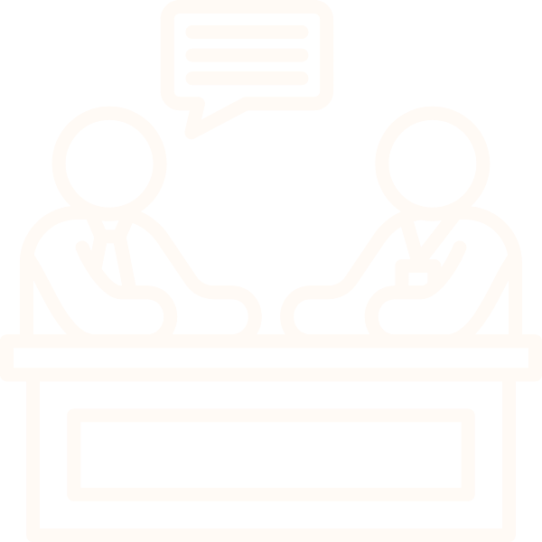 Two people in suits sitting across from each other at a table, engaging in a conversation, with a speech bubble above suggesting dialogue.
